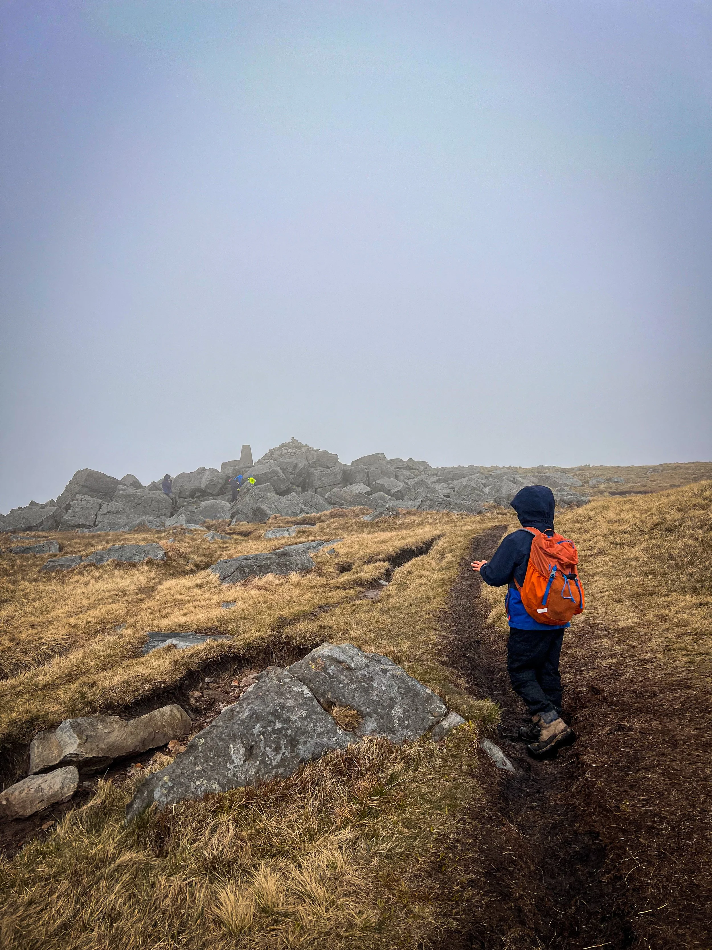 Walking to the summit of Great Whernside with trig and rocks ahead