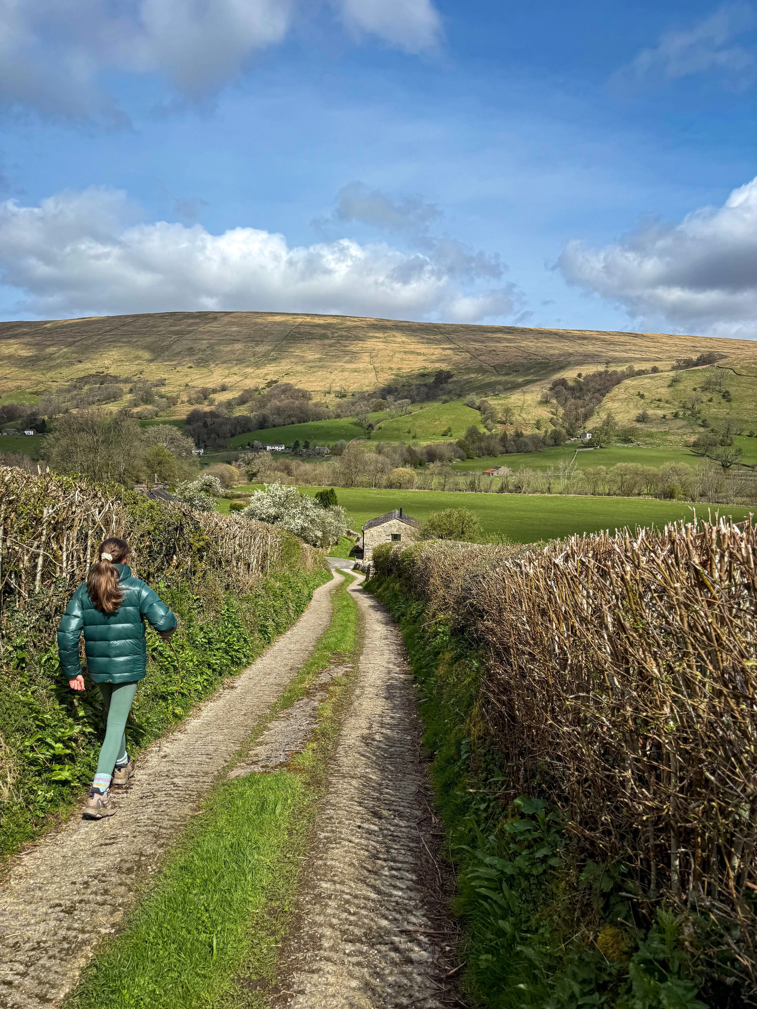 Child walking down lane in Dent with big fells in the distance