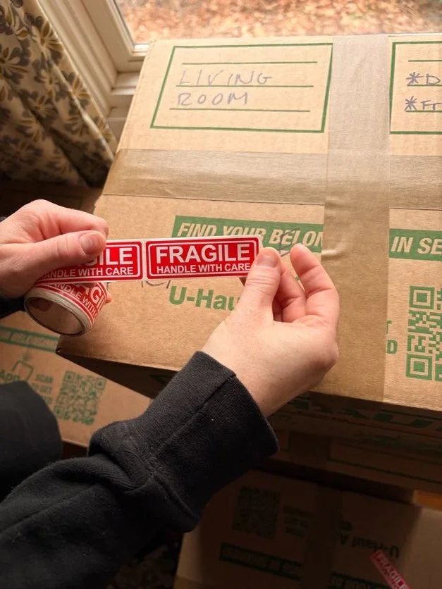 Organized packing supplies with labeled moving boxes and packing materials ready for a home move Asheville, NC