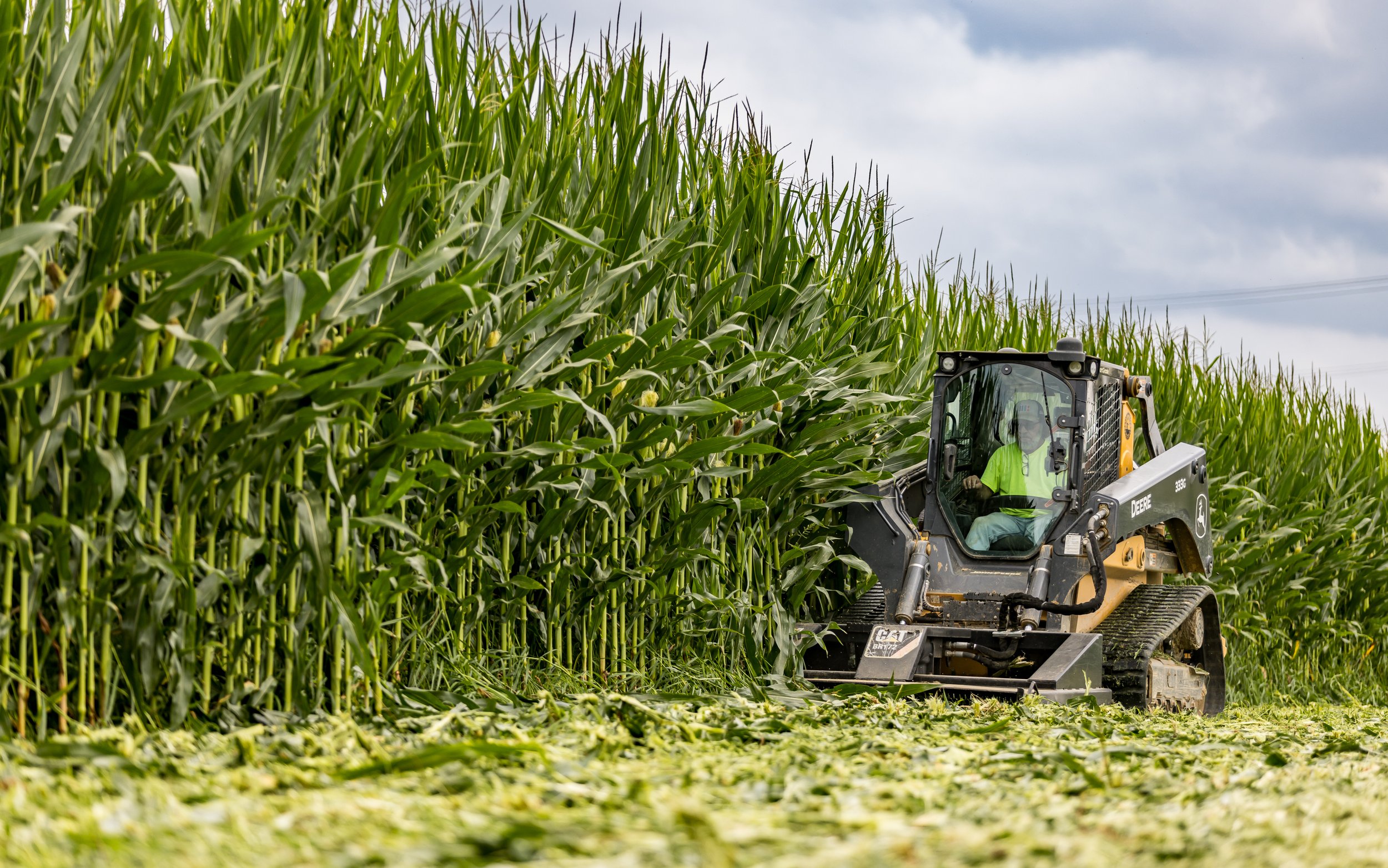 John Deere 333 Skid Loader mowing down corn at the Brandywine Farms project.
