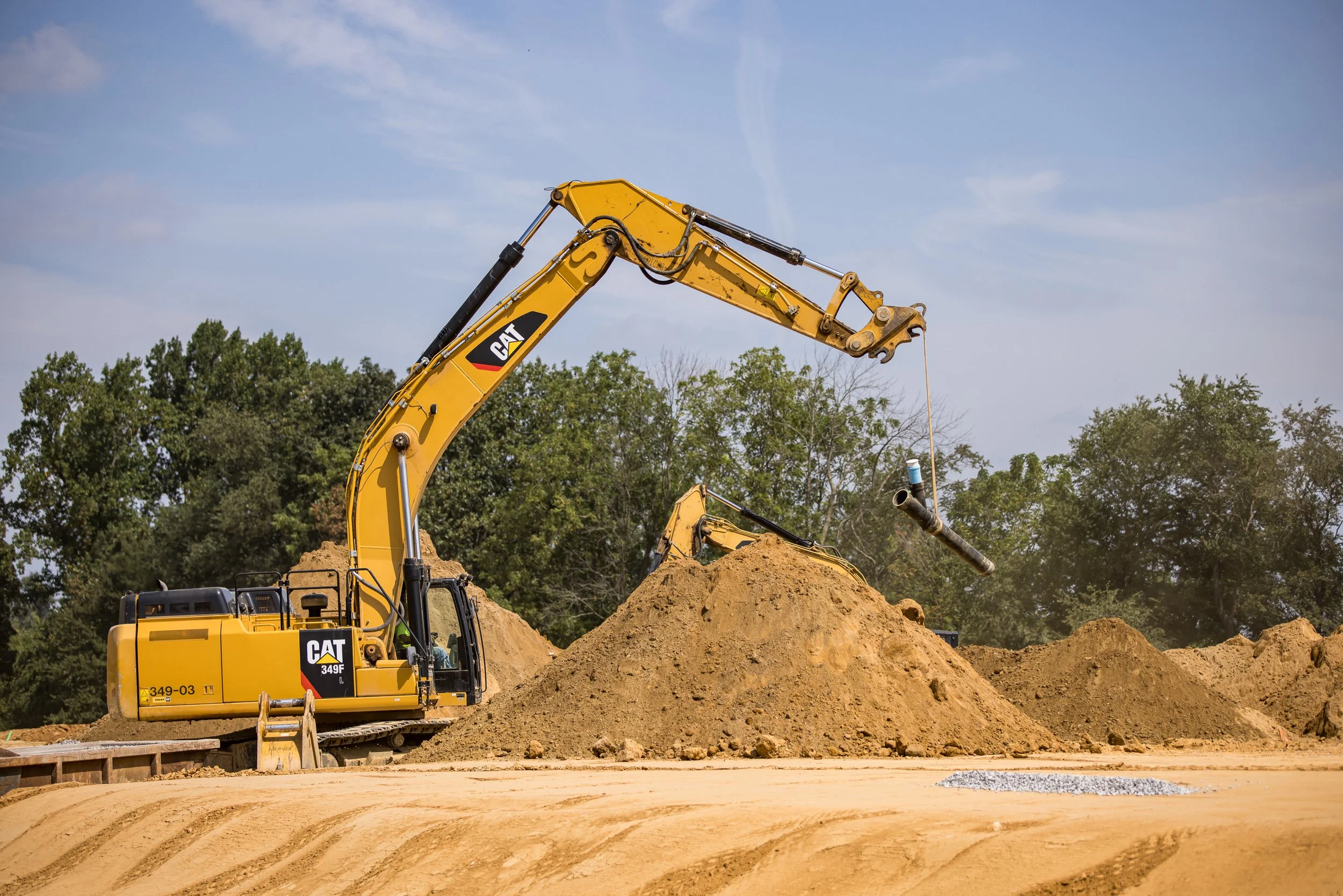 CAT 349 lifiting a section of sanitary sewer pipe at the Brandywine Farms project for Traditions of America
