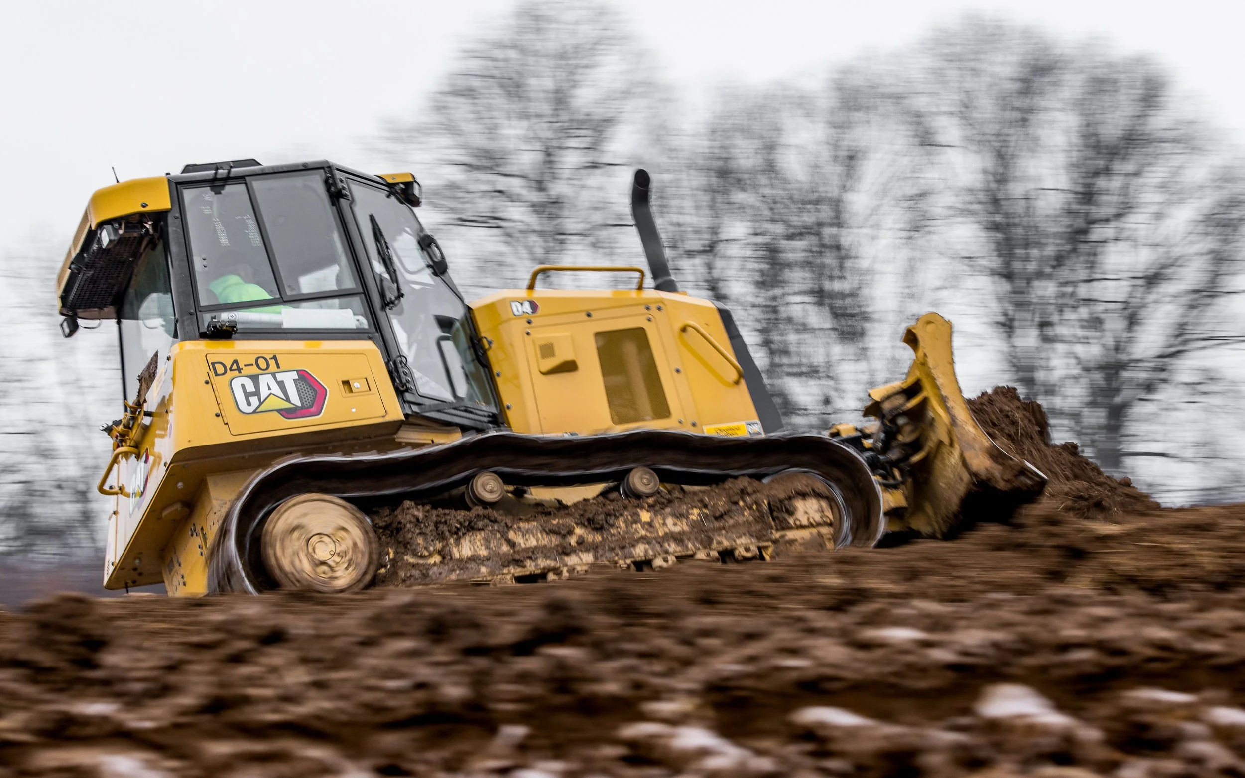 Caterpillar D4 dozer places topoil along the basin berm at the Westwynd Gardens project
