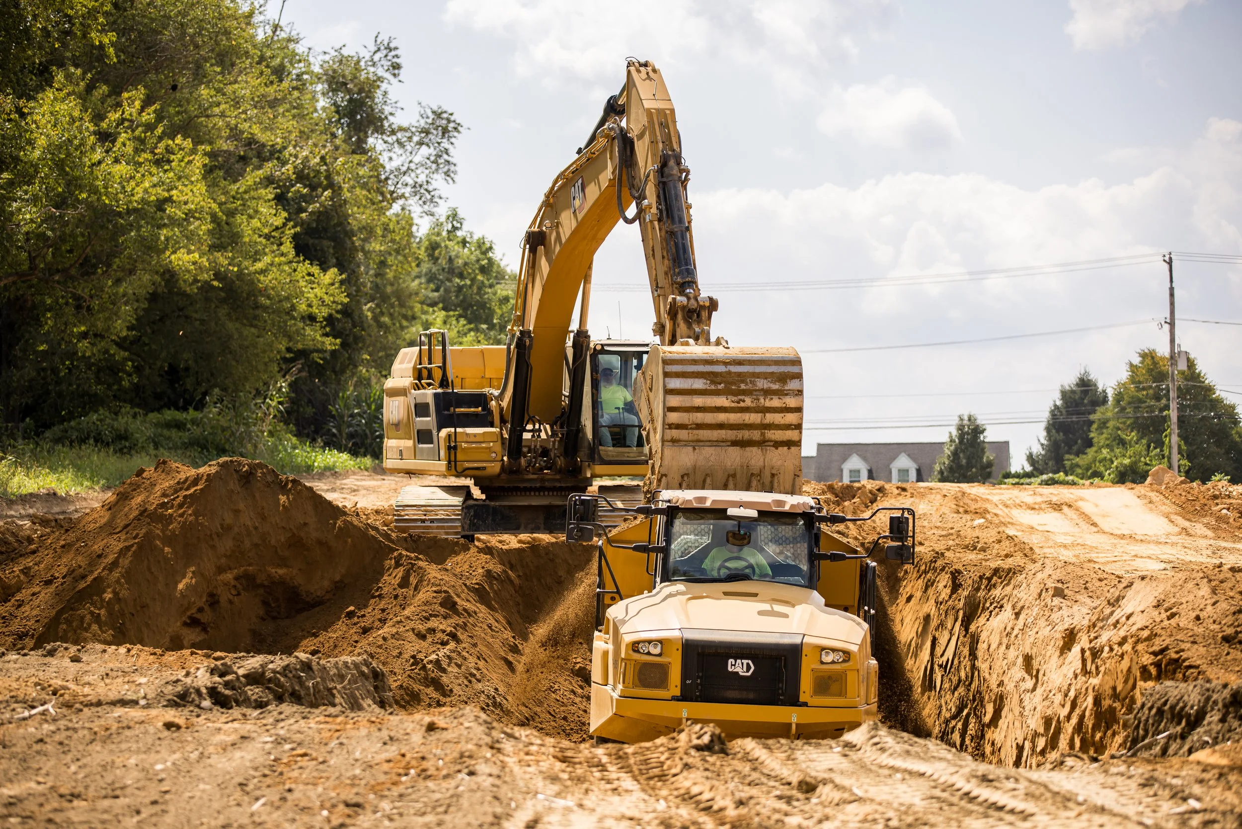 CAT excavator and dump truck working to cut lots in at the Brandywine Farms project for Traditions of America