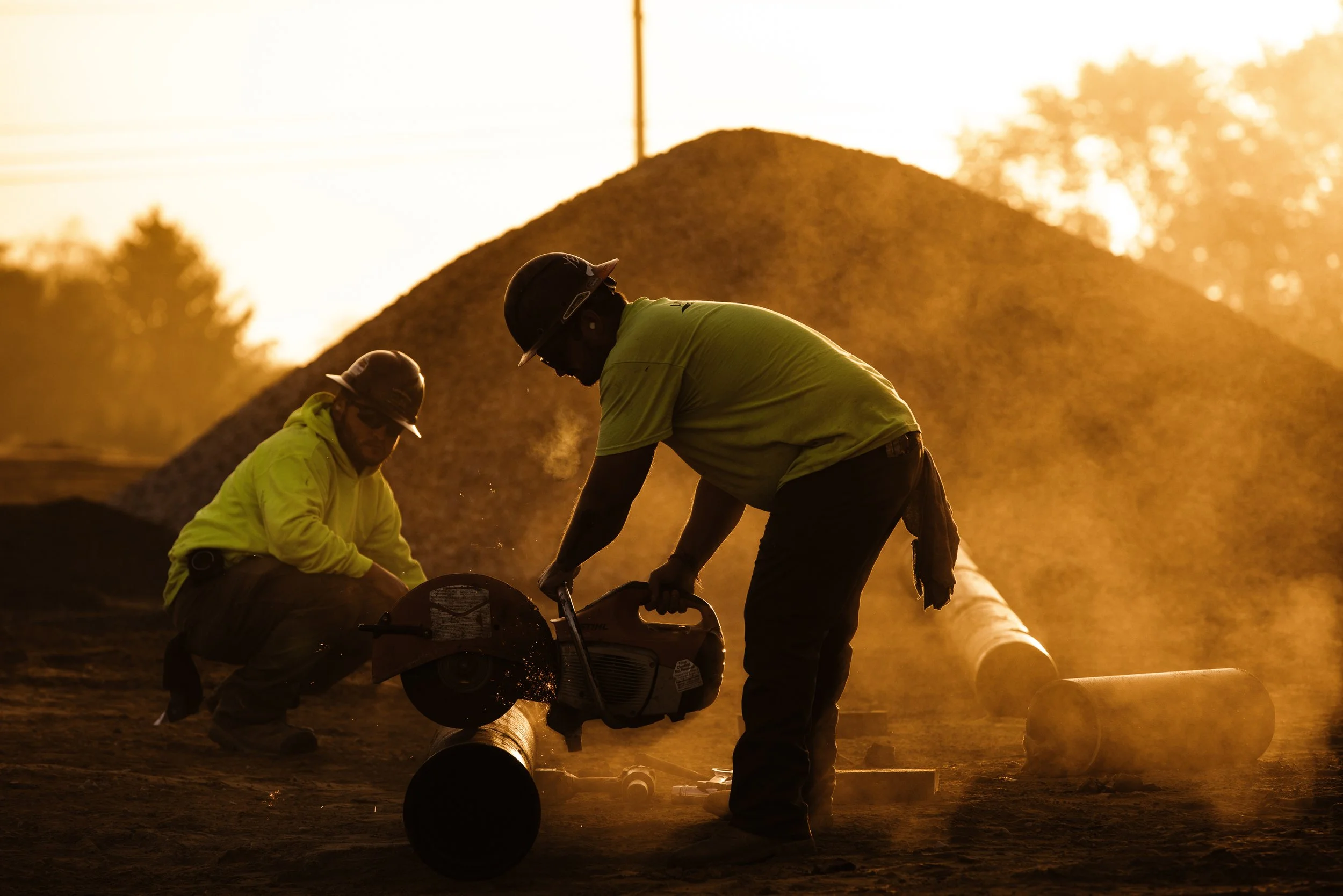 Pipe crew cutting ductile iron pipe for sanitary sewer installation
