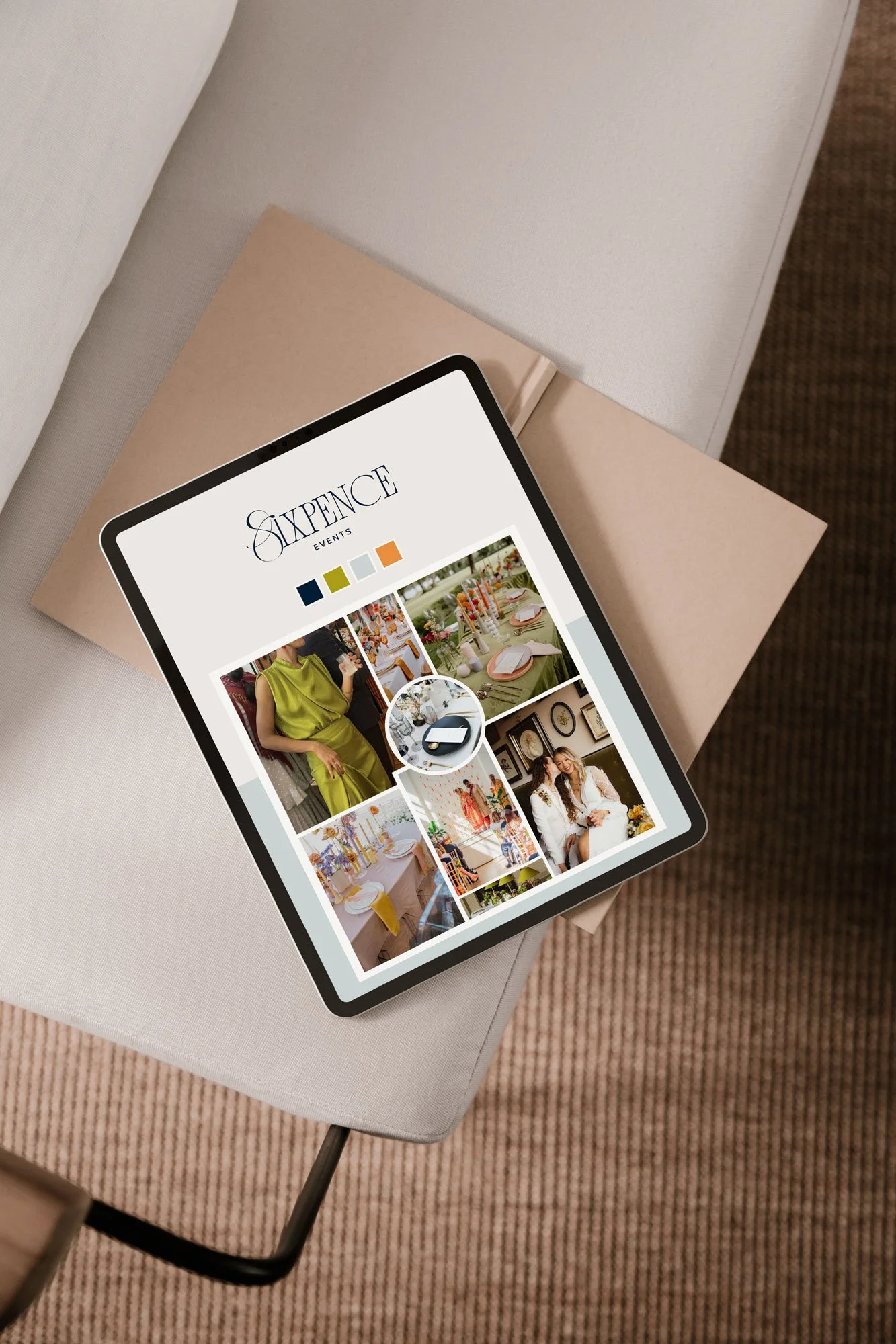 A tablet displaying a website for 'Sixpence Events' with images of event decorations and people, resting on a beige box on a light-colored upholstered surface.