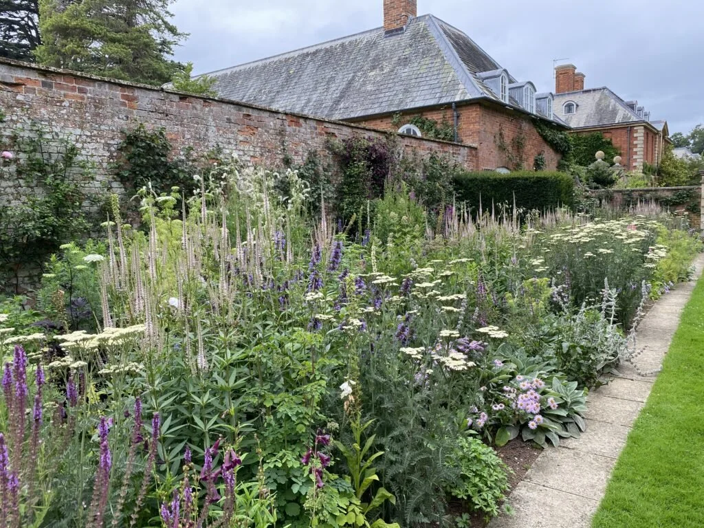 A large flower border along the side of statue walk