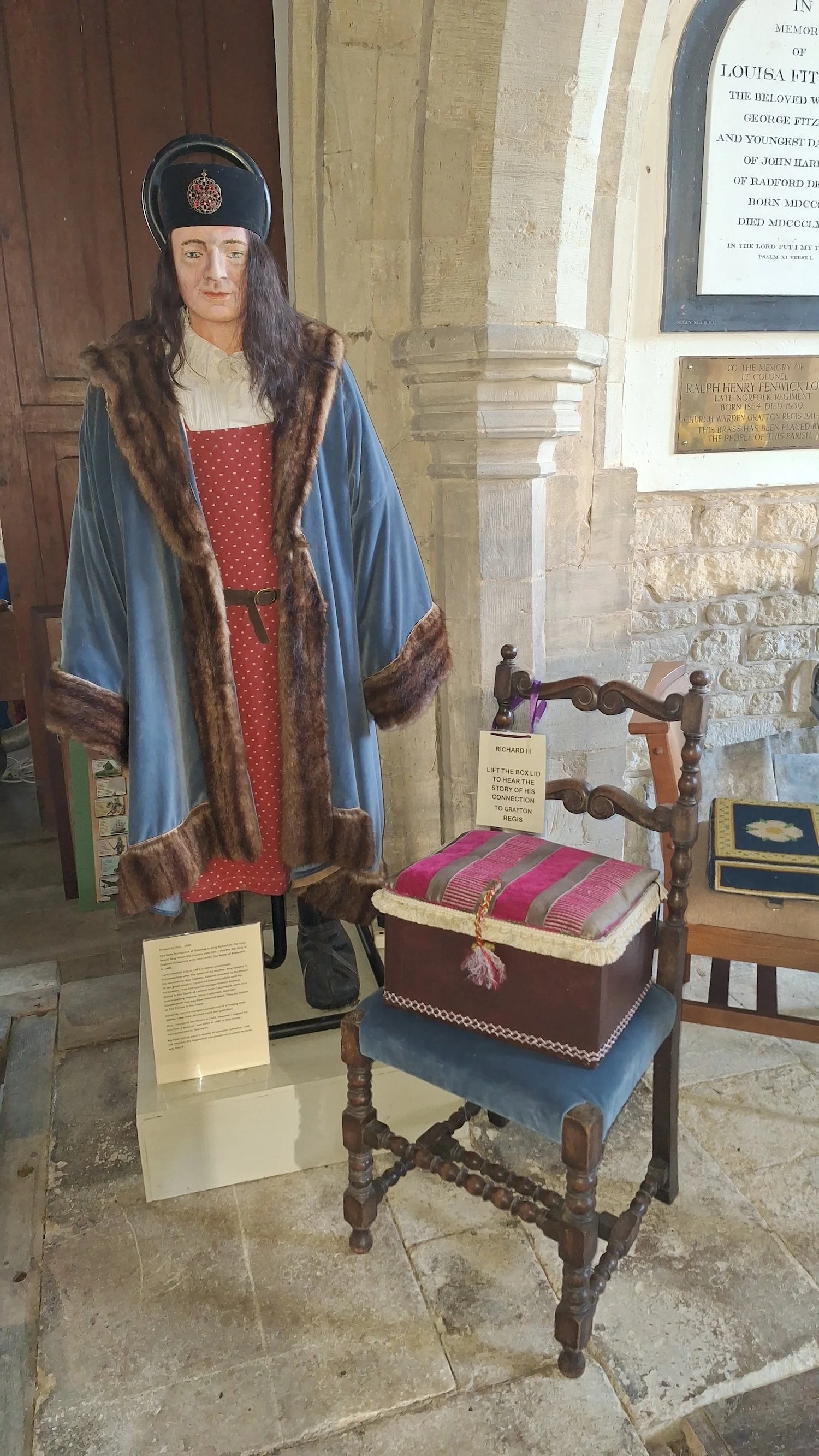 A historical figure in costume near a chair
