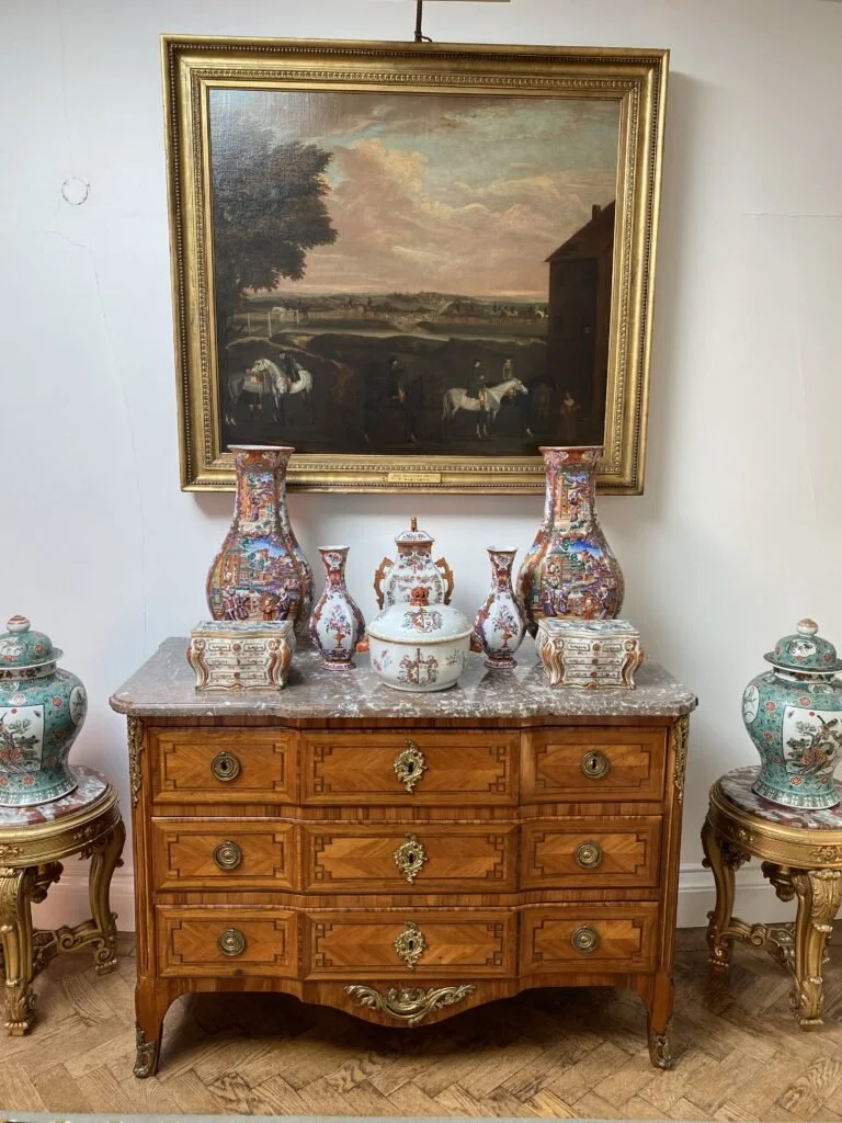 Old chest with ceramics on top and ginger jars either side with a landscape painting above