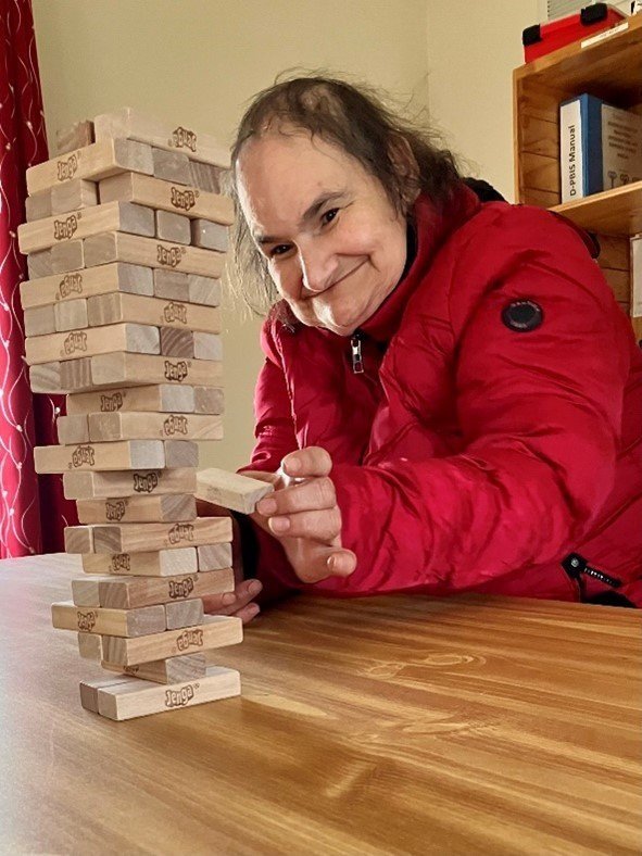  Residents of our group homes actively participate in engaging activities. This Fislerville group home individual is playing an intense game of Jenga.       