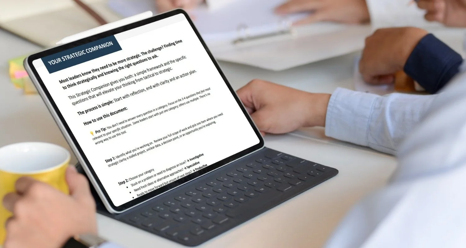 Man's arm at table with laptop displaying strategic thinking resource