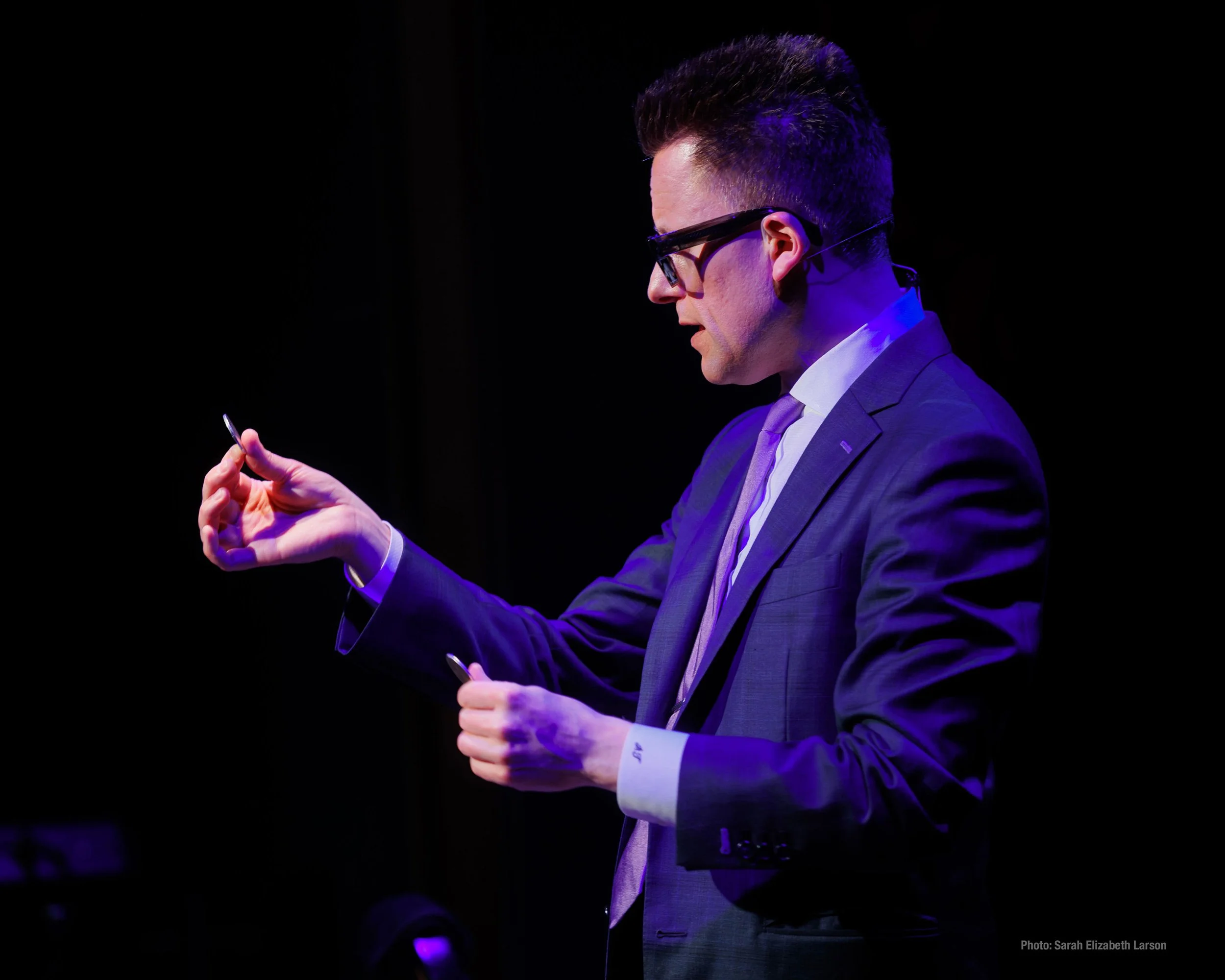 Arthur Trace performing a coin trick with silver dollars.