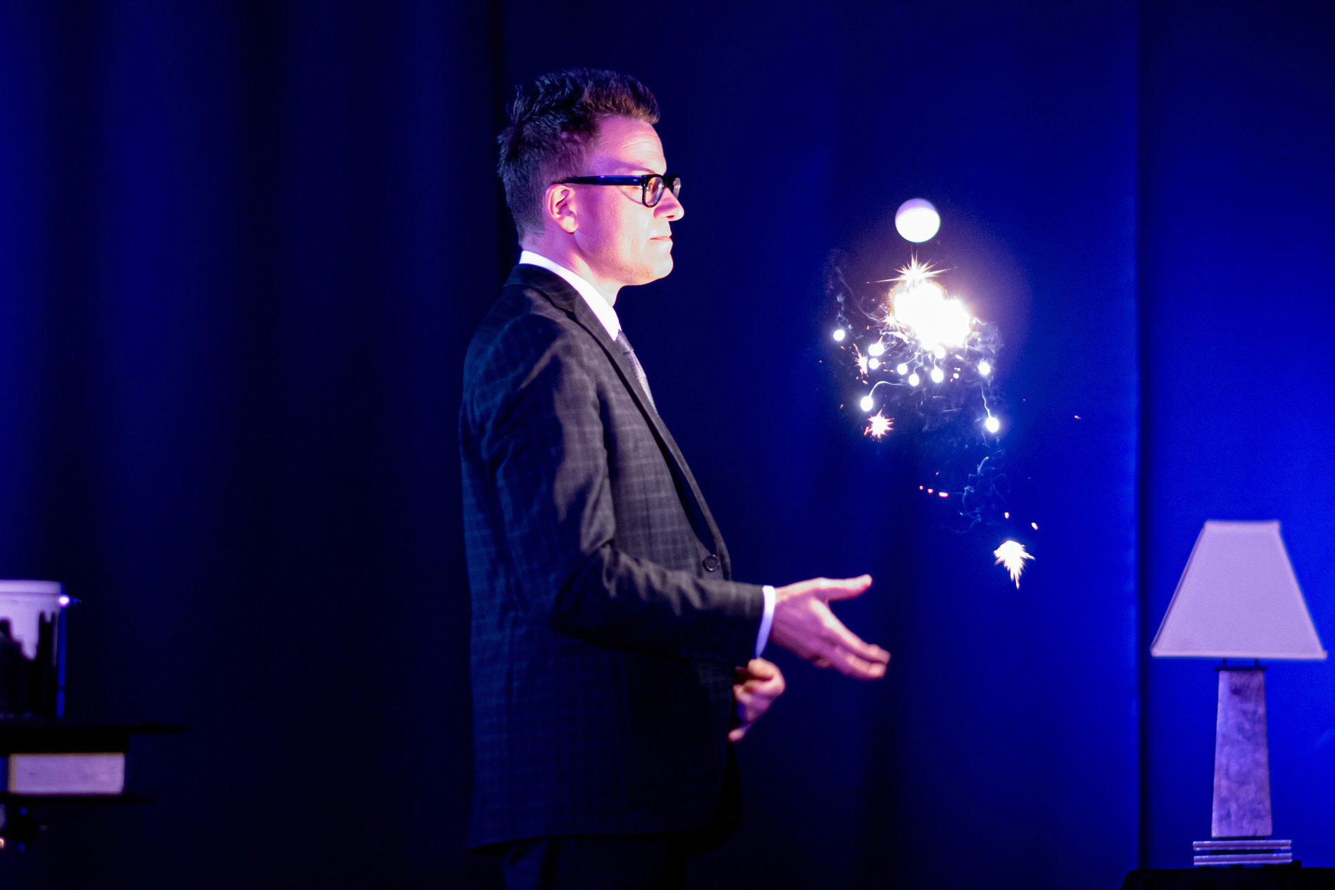 Arthur Trace on stage with a ball, midair, appearing from a flash of fire.