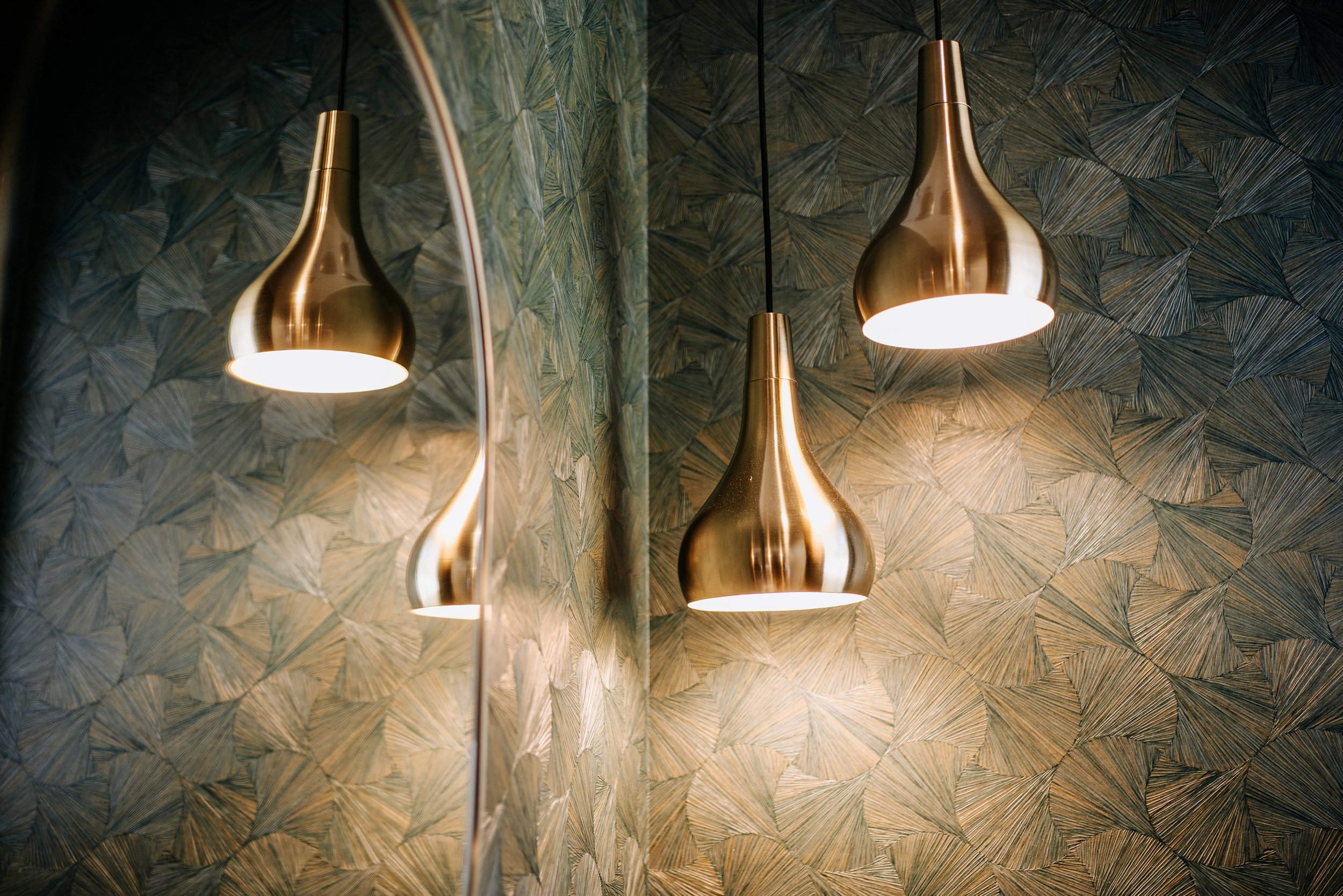 Gold pendant lights with green textured wallpaper - powder room