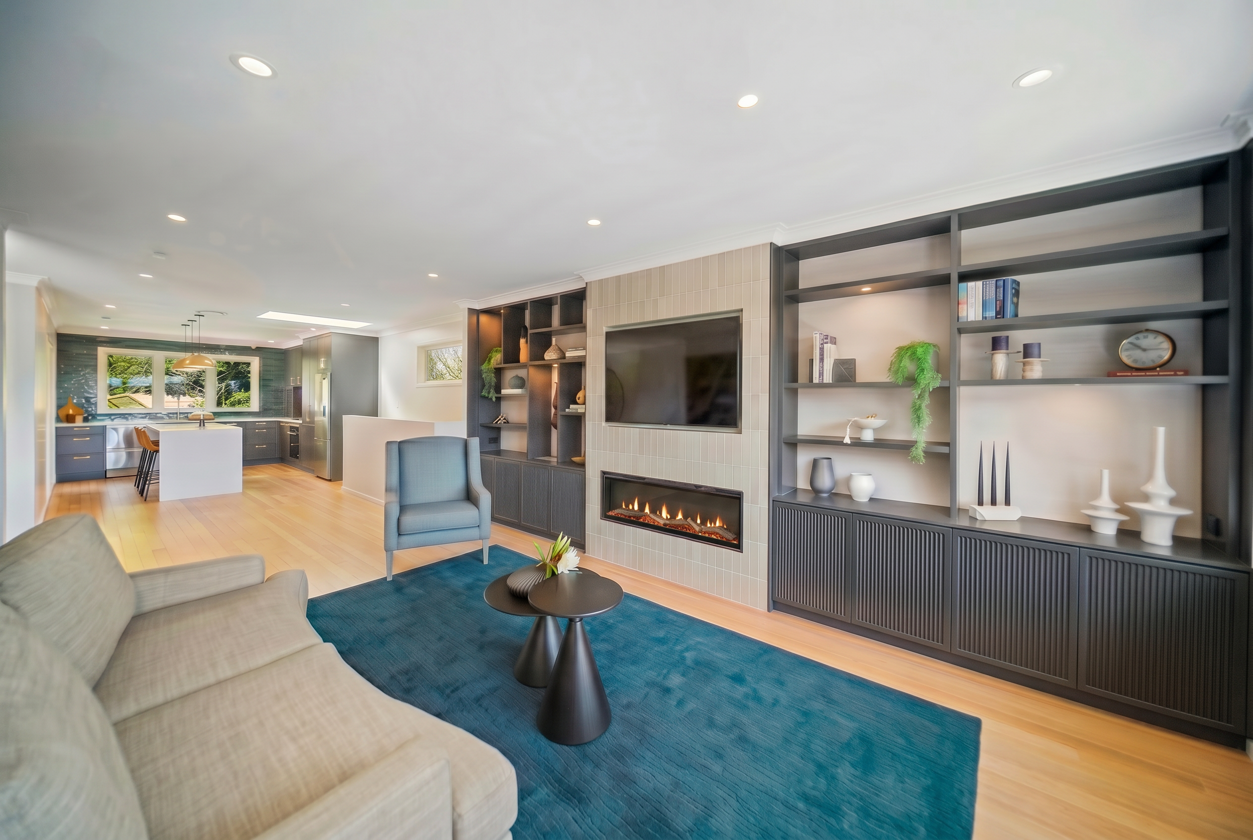 Open plan renovation living room teal, and grey. Custom Cabinet