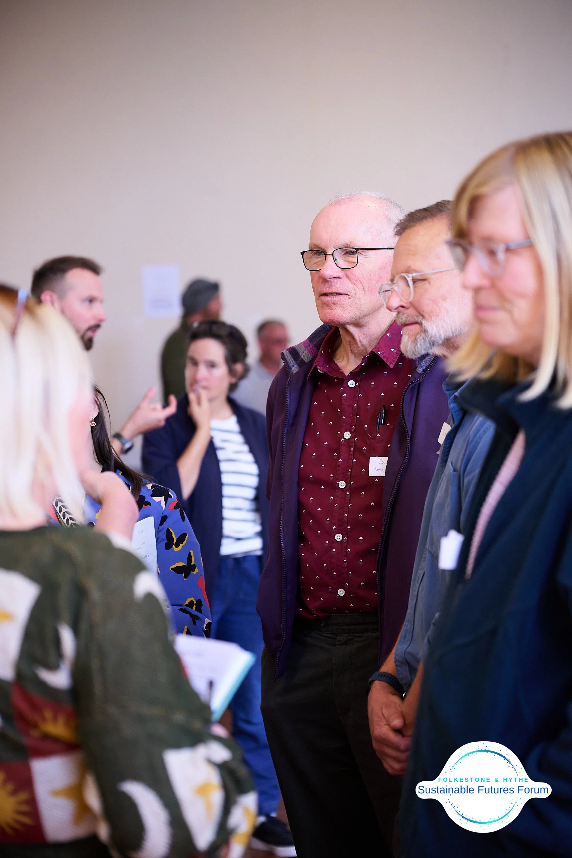 Group of people engaged in conversation at the Folkestone & Hythe Sustainable Futures Forum.