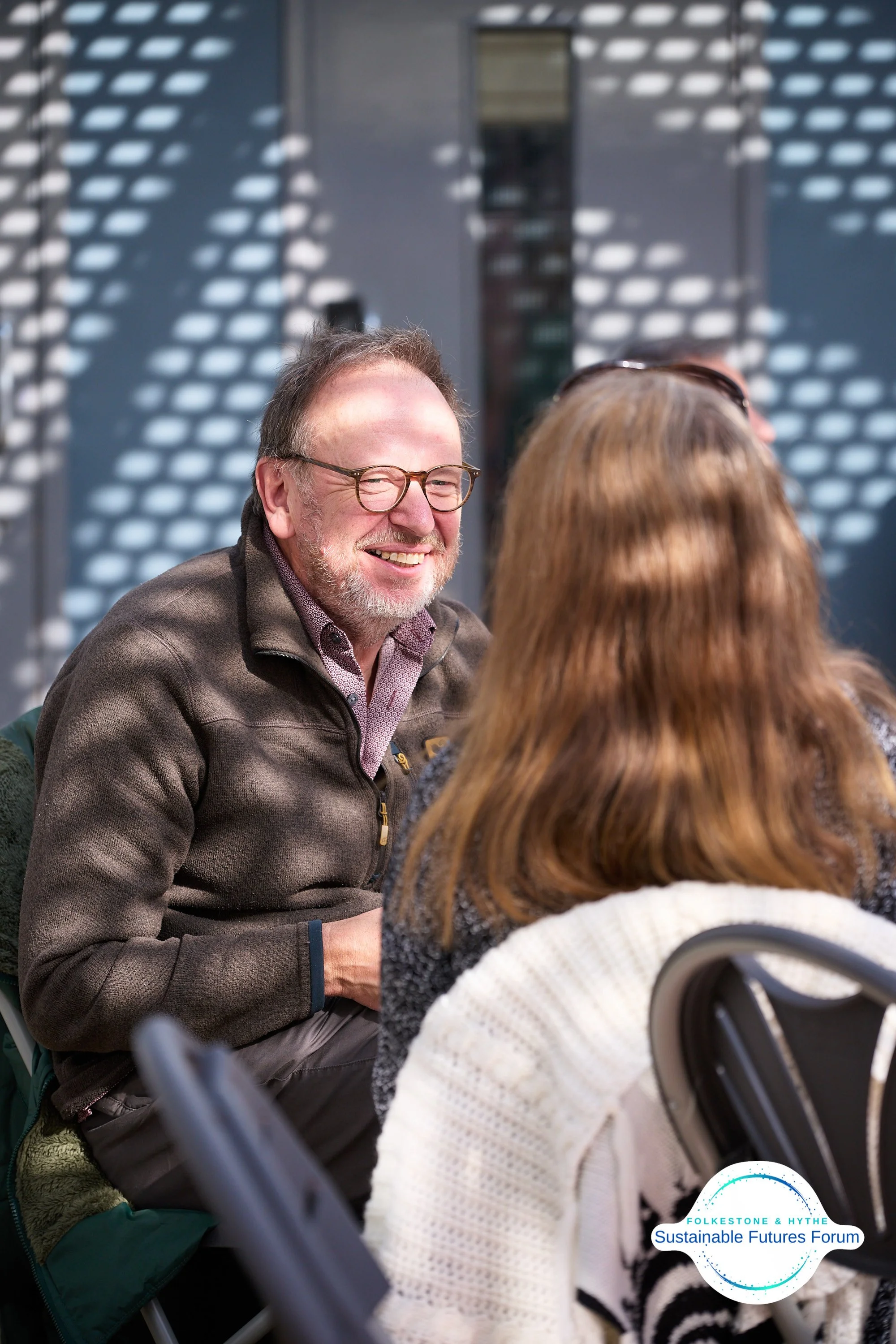 Man smiling at interlocutor in dappled light