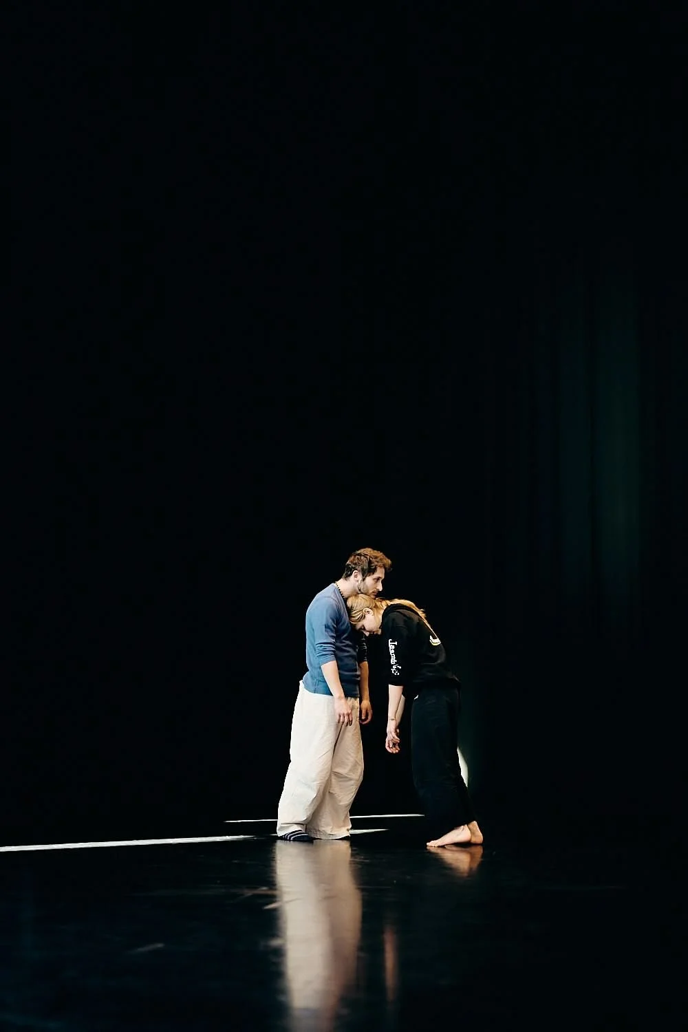Man and woman dancing in a black room