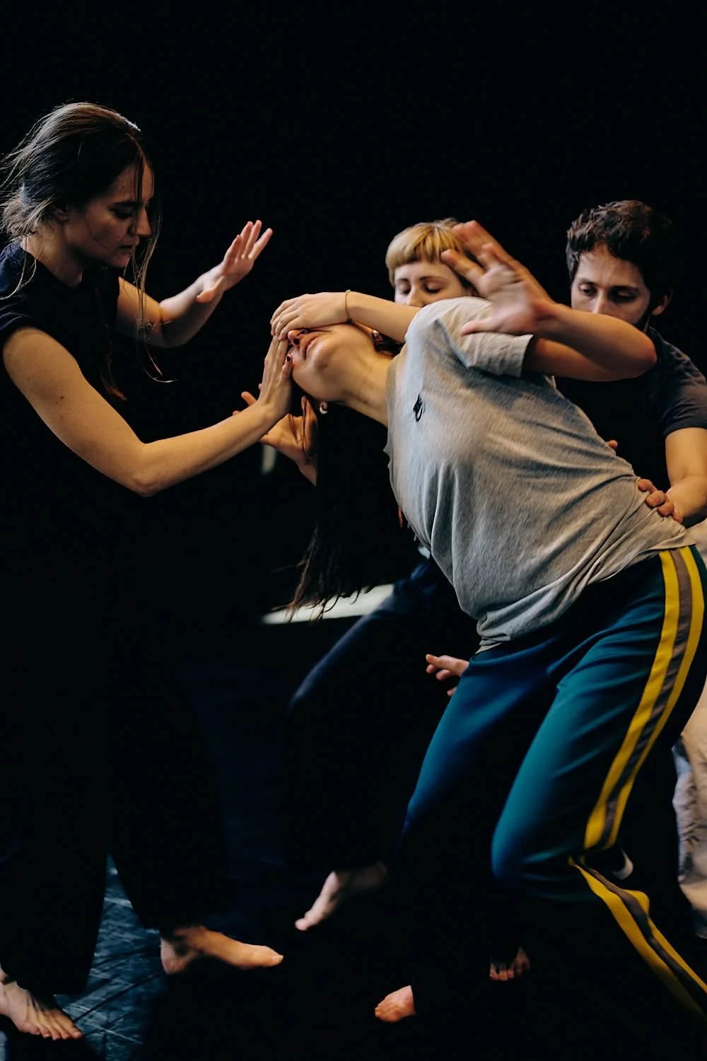 Group of people practicing self-defense or martial arts focusing on a woman defending against multiple attackers.