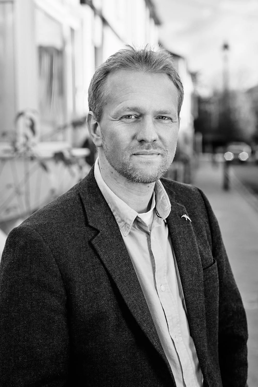 Male accountant standing by a road in black and white