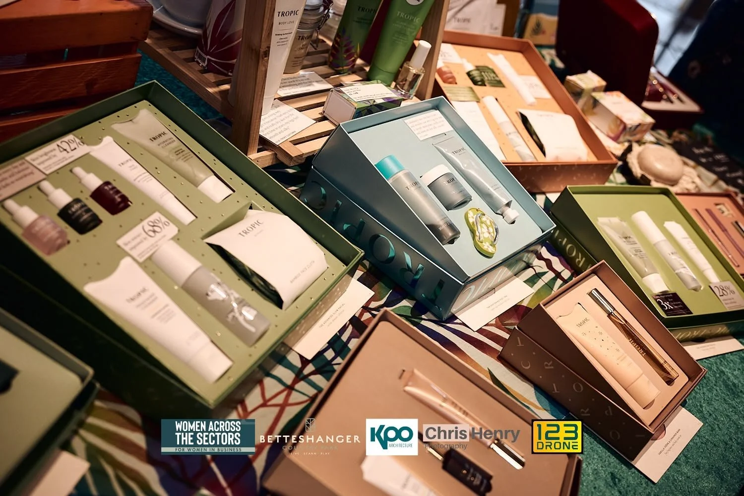 Display of skincare and beauty products in colorful boxes at a market or trade fair.