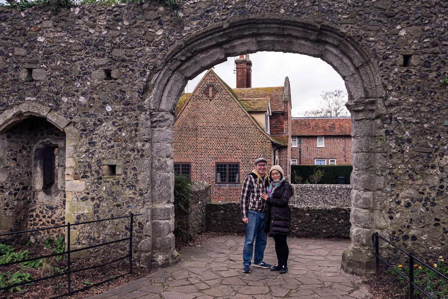 Man and woman standing next to each other under a stone arch