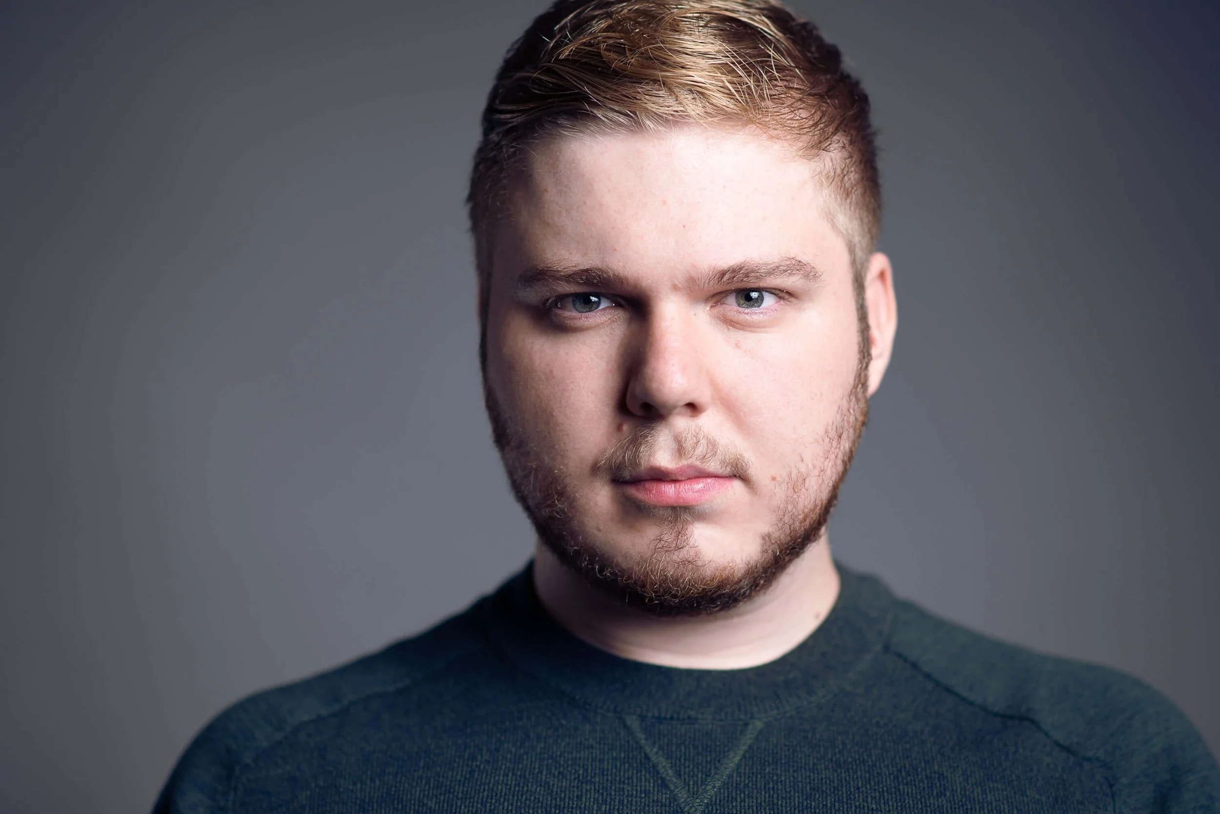 Headshot of a male student in a green jumper