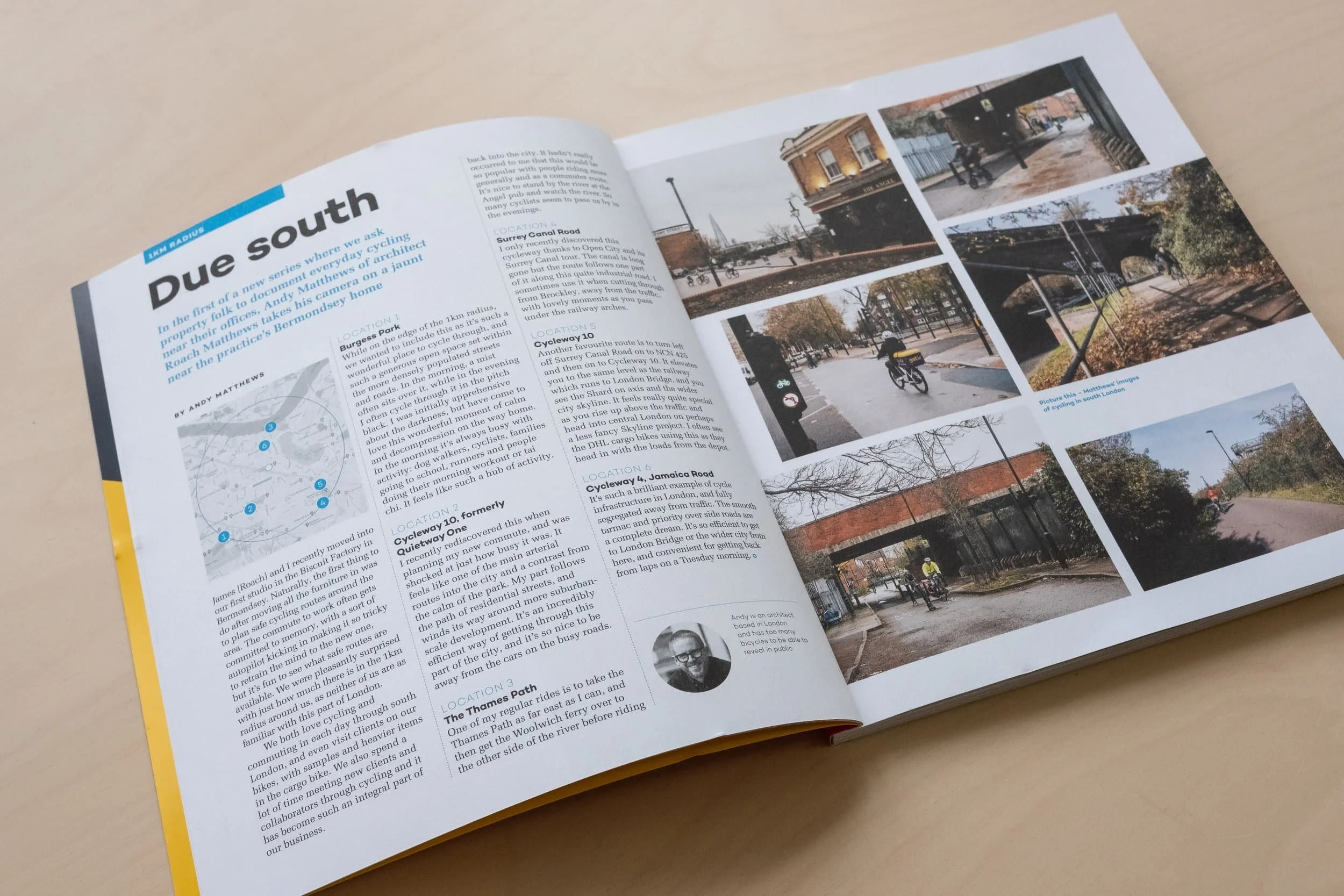 Image of a magazine laid open on a plywood desk with text to the left spread and a gallery of images to the right.