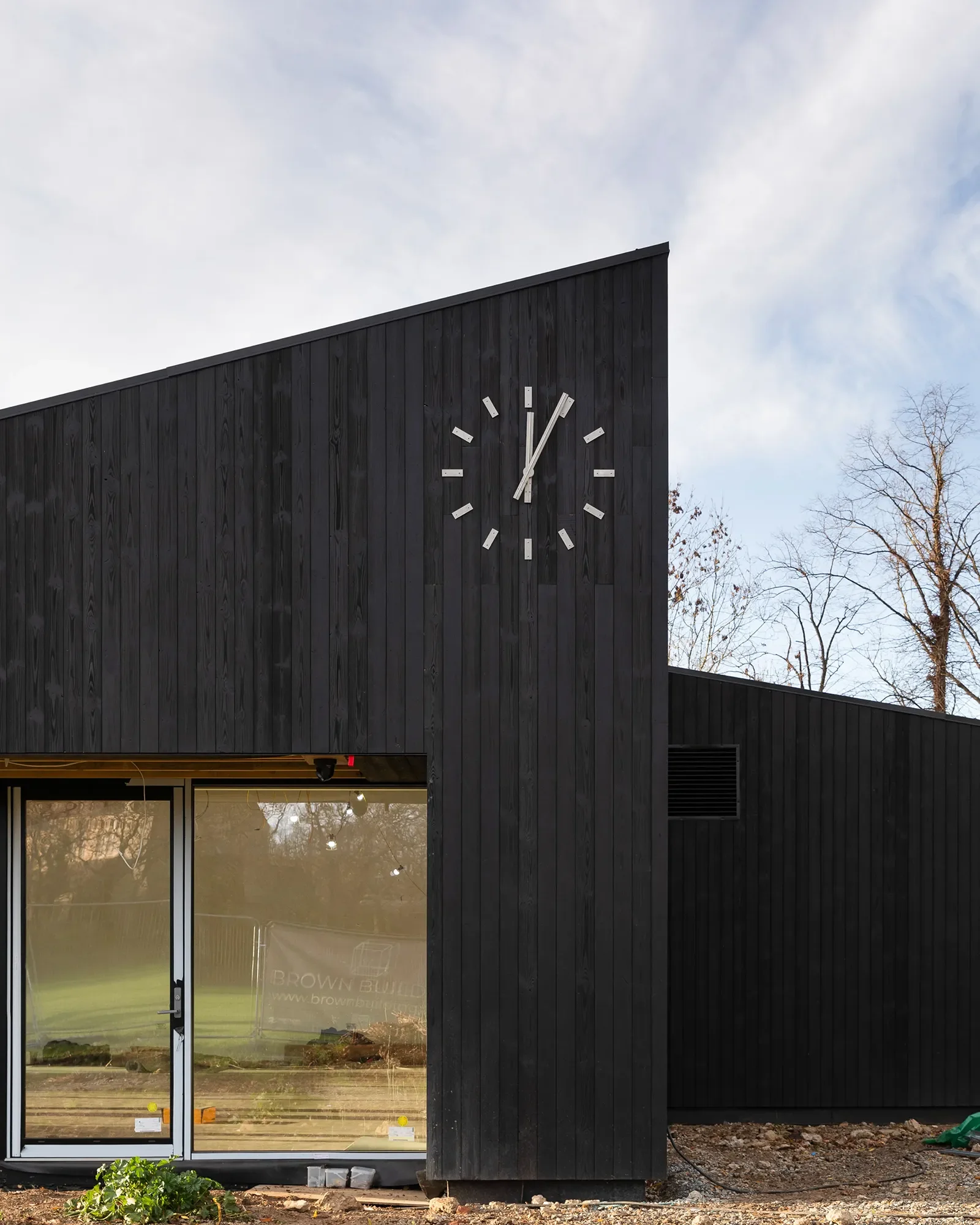 Site progress, December 2025. Shou Sugi Ban cladding, corrugated roofing, and new public clock © Rachel Ferriman.