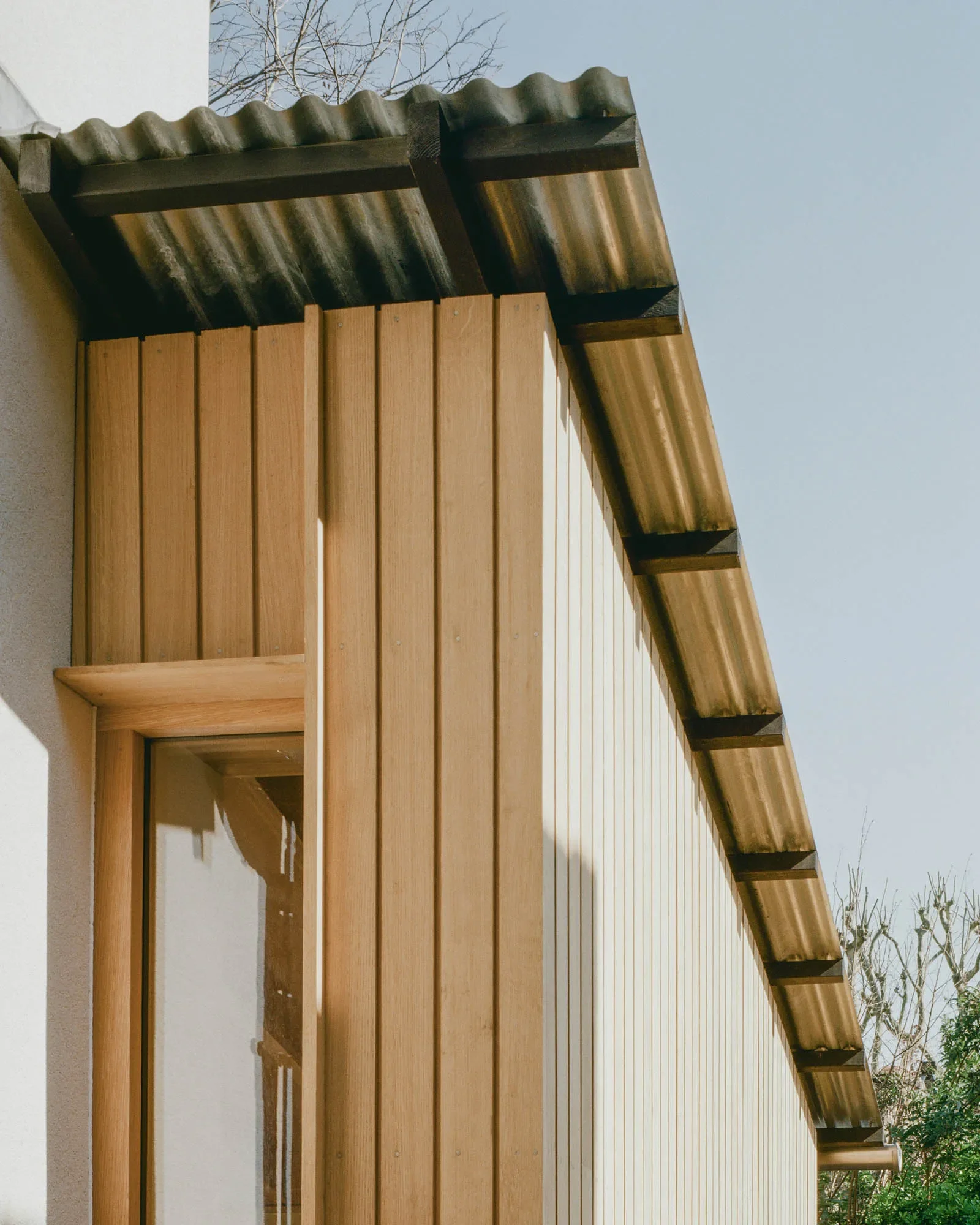 Oak cladding with sinusoidal roof cladding to extension © Owen Vidler