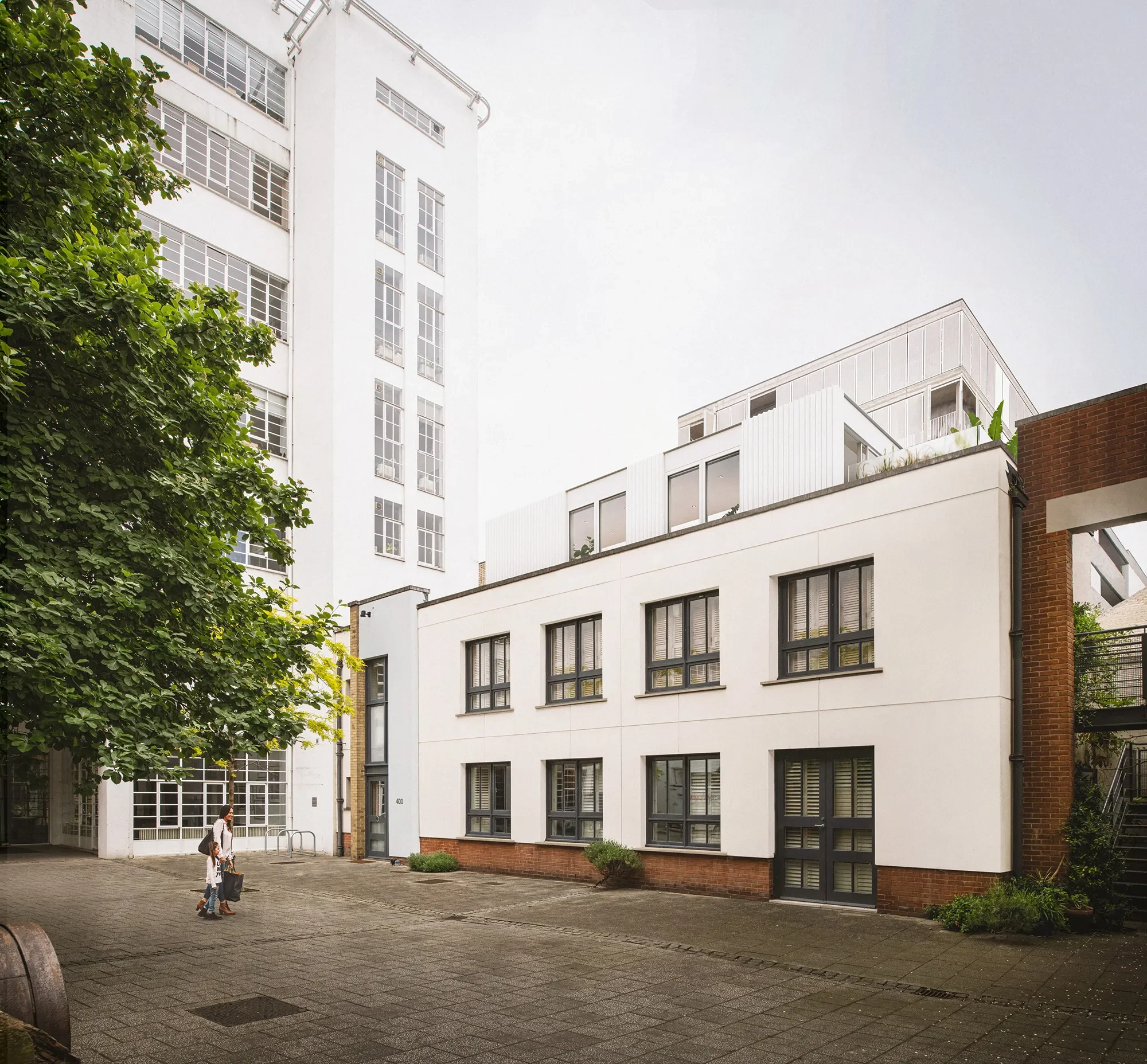 Alaska Factory courtyard view - existing two-storey building with Art Deco 600 building behind. Existing tree digitally remove to show proposal fully. © Tandem Studios