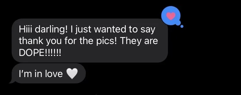 A screenshot of text messages on a black background. The first message says, 'Hiii darling! I just wanted to say thank you for the pics! They are DOPE!!!!!!' The second message says, 'I'm in love' with a white heart emoji. There is also a heart reaction symbol above the first message.