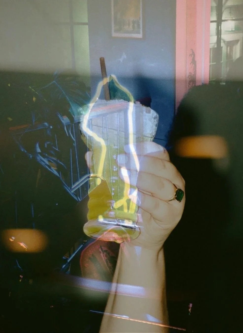 Double exposure base image is a blue neon naked cut out sign layered on top is a photo of emmas hand holding a pineapple cocktail with her huge emerald engagement ring visible- images taken by Taylor Tolbert / TTOLBPHOTOG a Chicago photographer