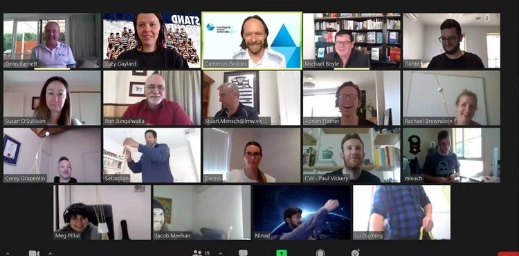 A screenshot showing a lot of people in a video call smiling and doing different things.