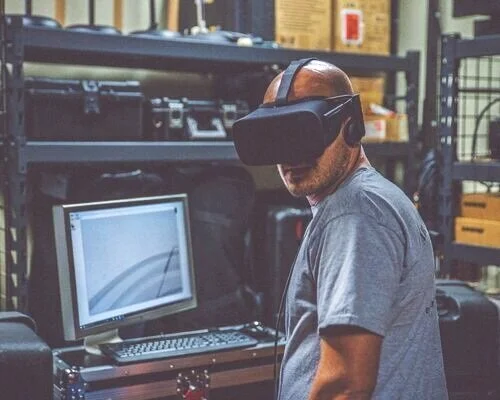 A man sitting in an office wearing a virtual reality headset