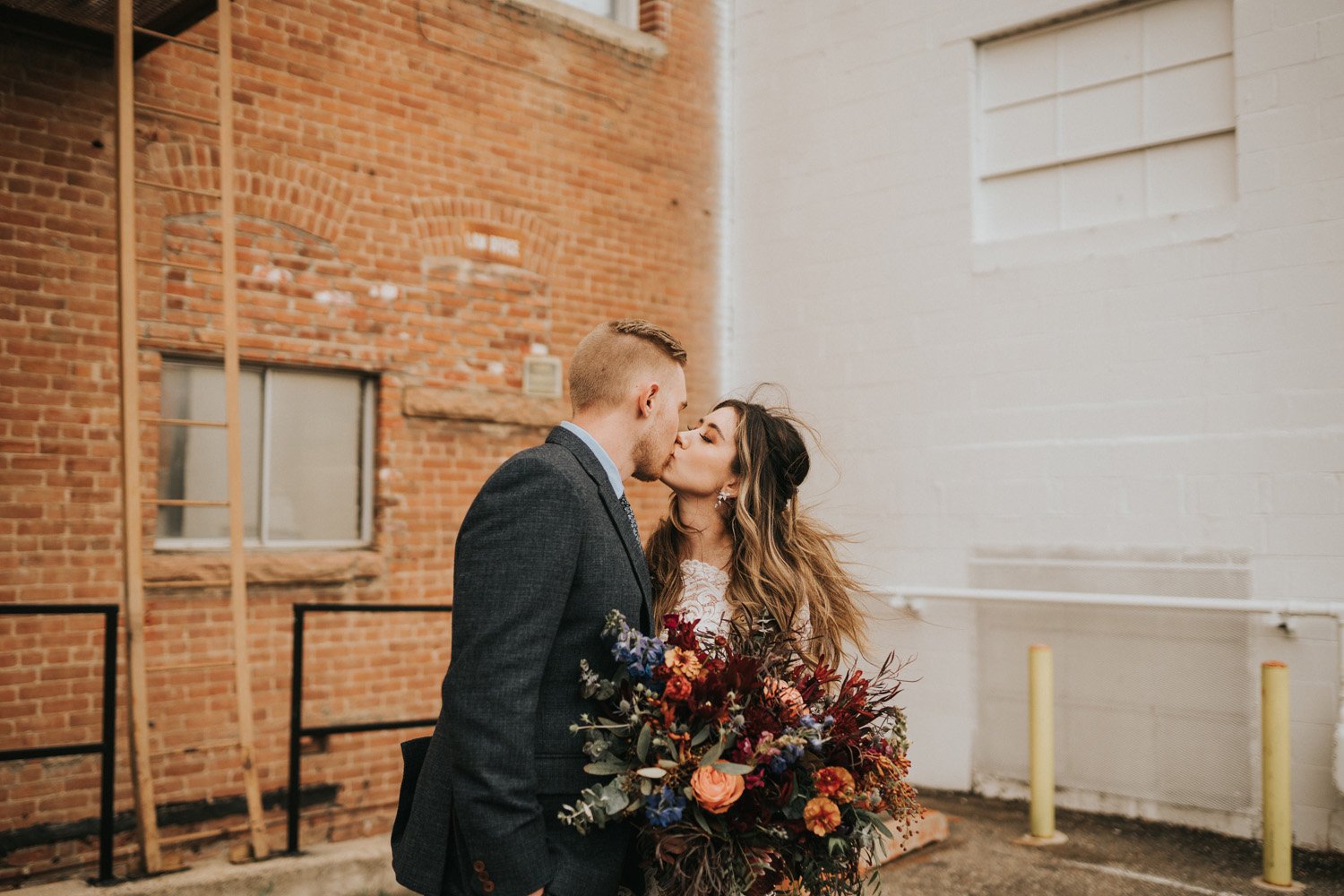 Plume&Furrow-Wedding-Florist-Kaiti&Joe-theStVrain-May-Colorado-JillHouserPhoto-bride-groom-kiss-bouquet.jpg