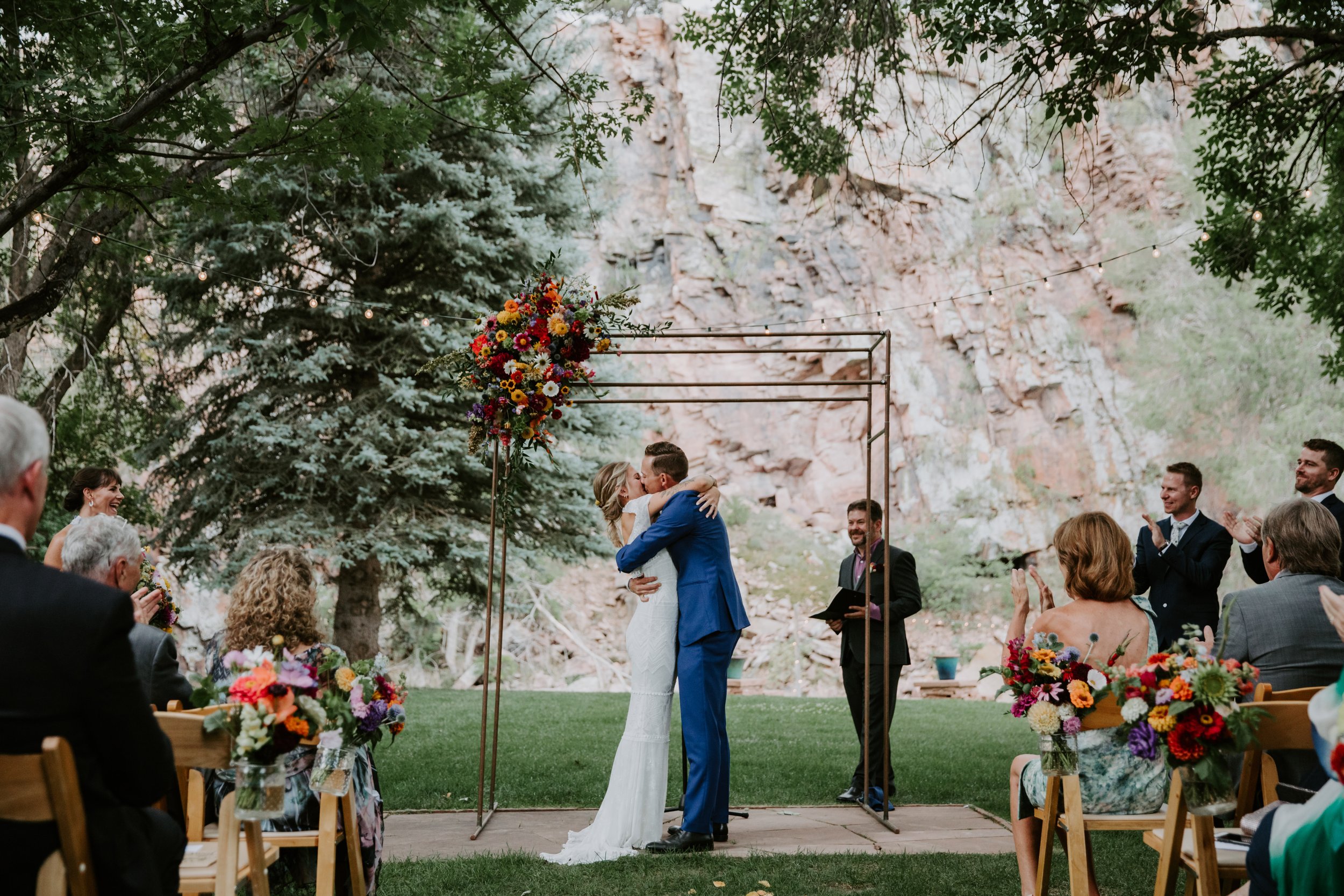 Plume&Furrow-Wedding-Florist-Sarah&Jordan-AshleyTiedgenPhotography-River-Bend-August-Colorado-Bride-Groom-Kiss-Arbor-Decor.jpg