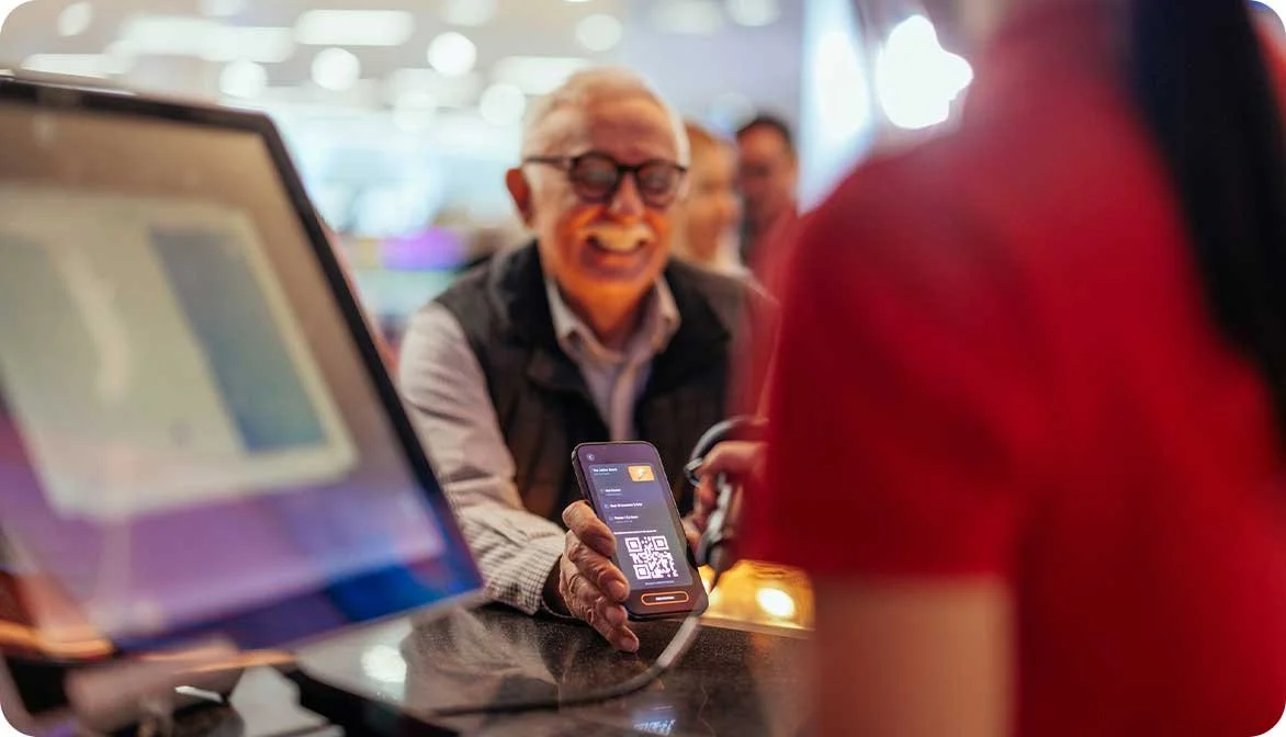 A close-up of a person scanning a digital ticket from a traveler's smartphone, demonstrating how a flexible API streamlines ticket validation and on-site entry operations.