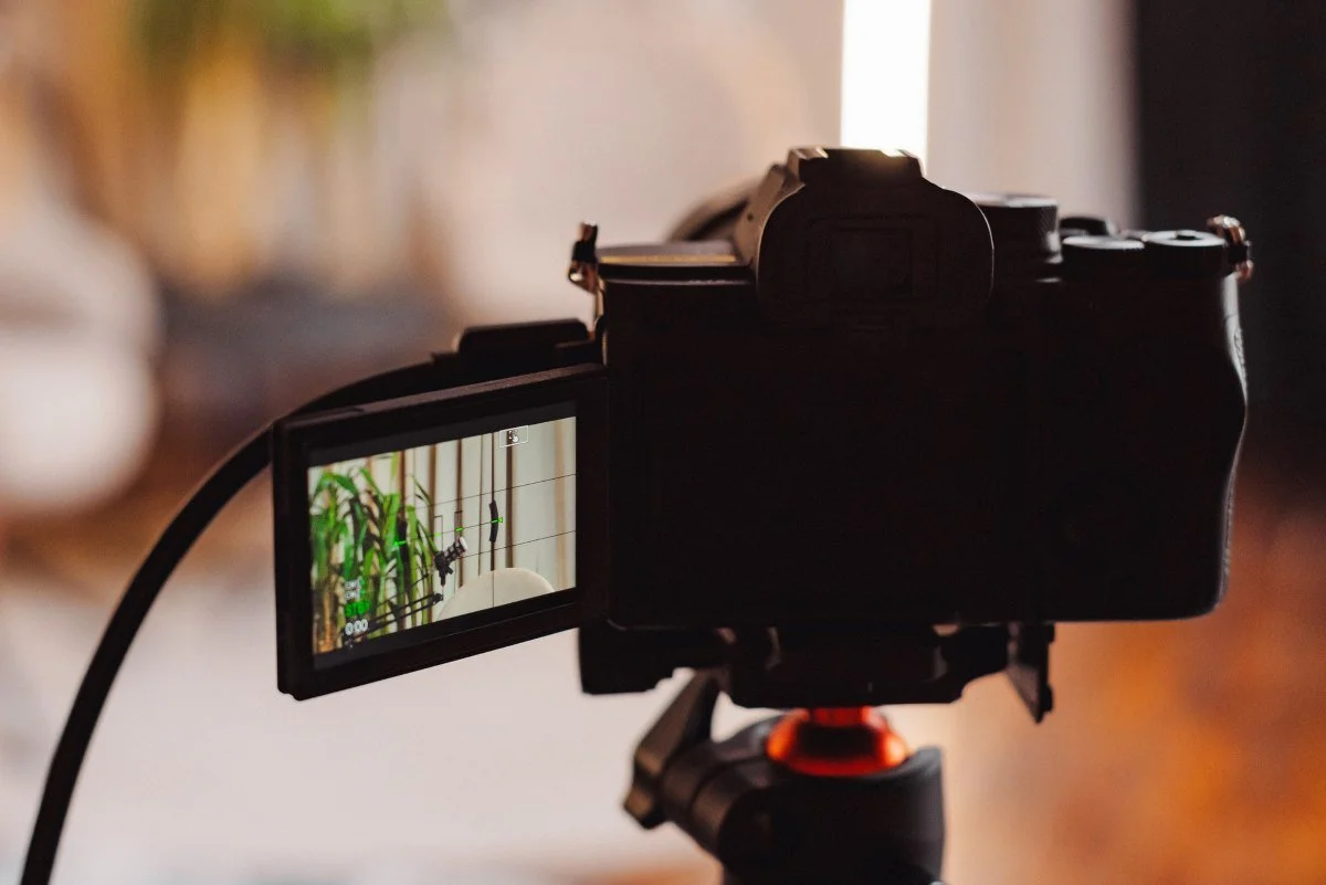 Recording a podcast episode with a microphone and camera setup in a cozy home studio environment