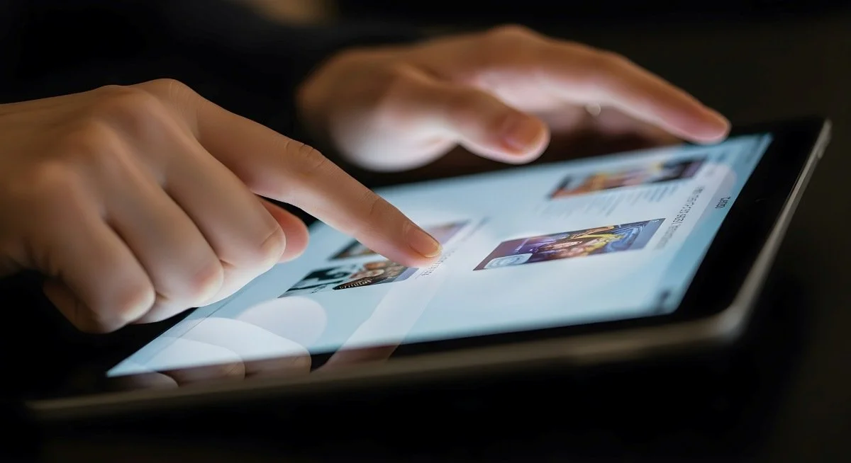 Close up of finger touching a tablet screen browsing online