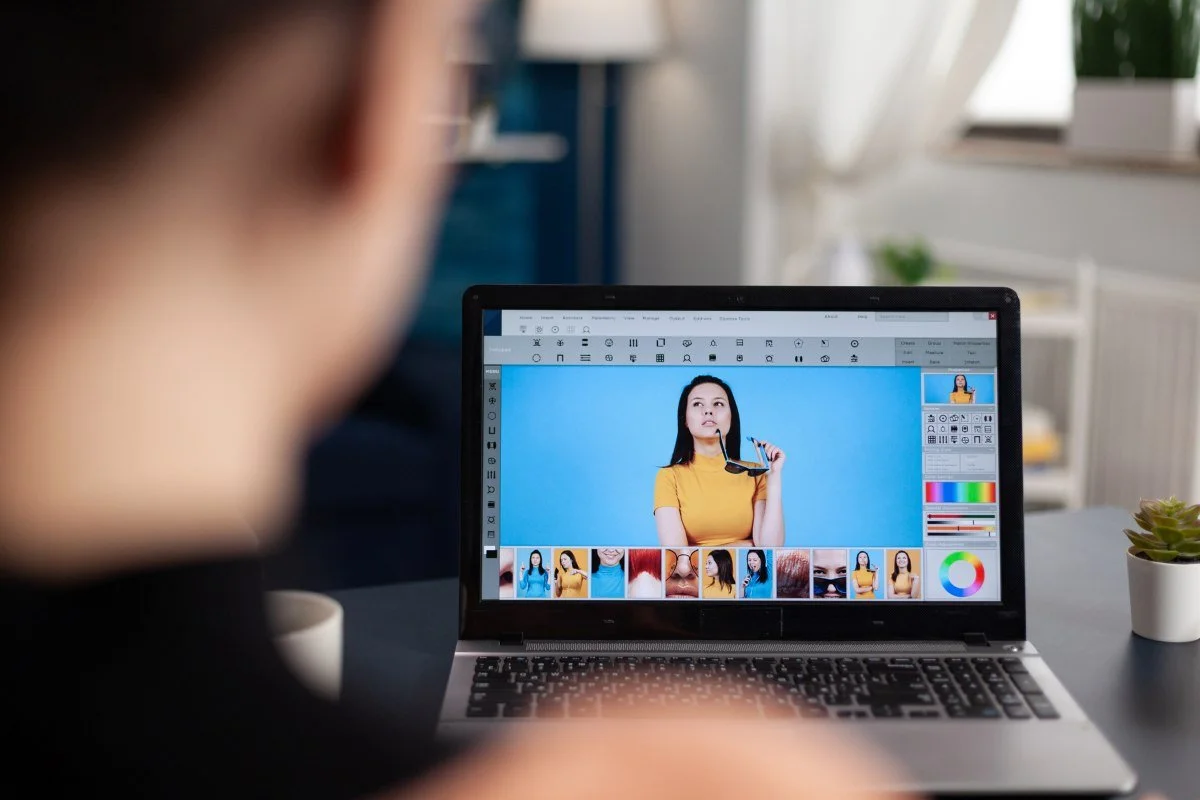 Student retouching photos on laptop using editing software