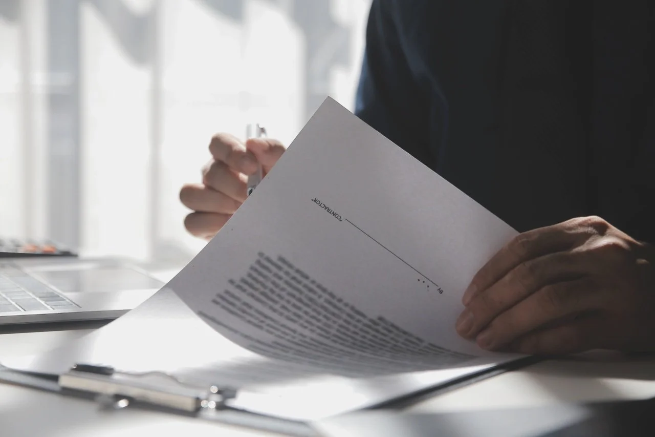 man reviewing document containing bank statement at office workplace