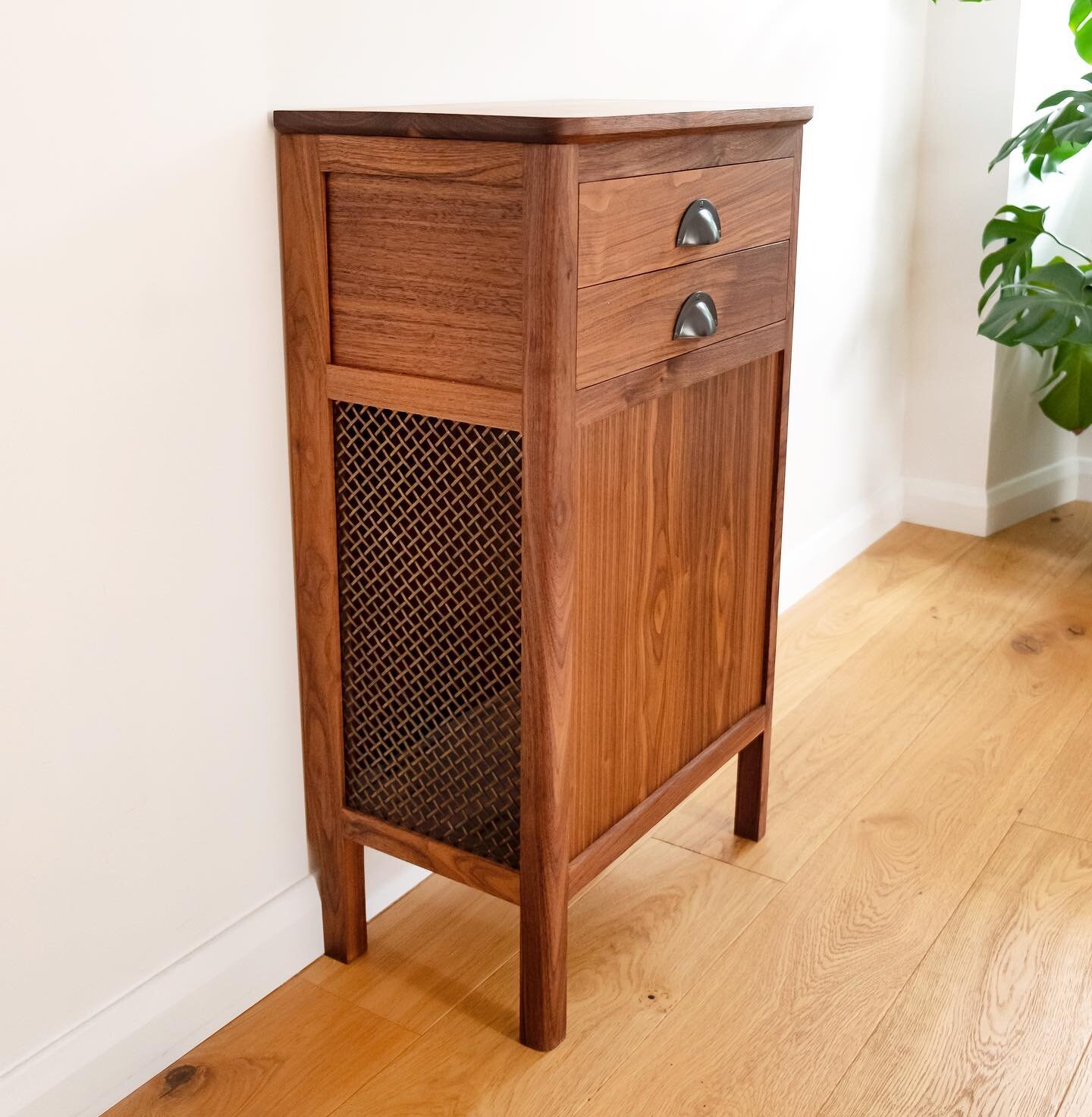 This walnut hall cabinet is built specifically to hold the client&rsquo;s air purifier and provide a docking space for the robot Hoover underneath. The brass mesh allows for ample flow for the purifier and the height below is just right for the vacuu