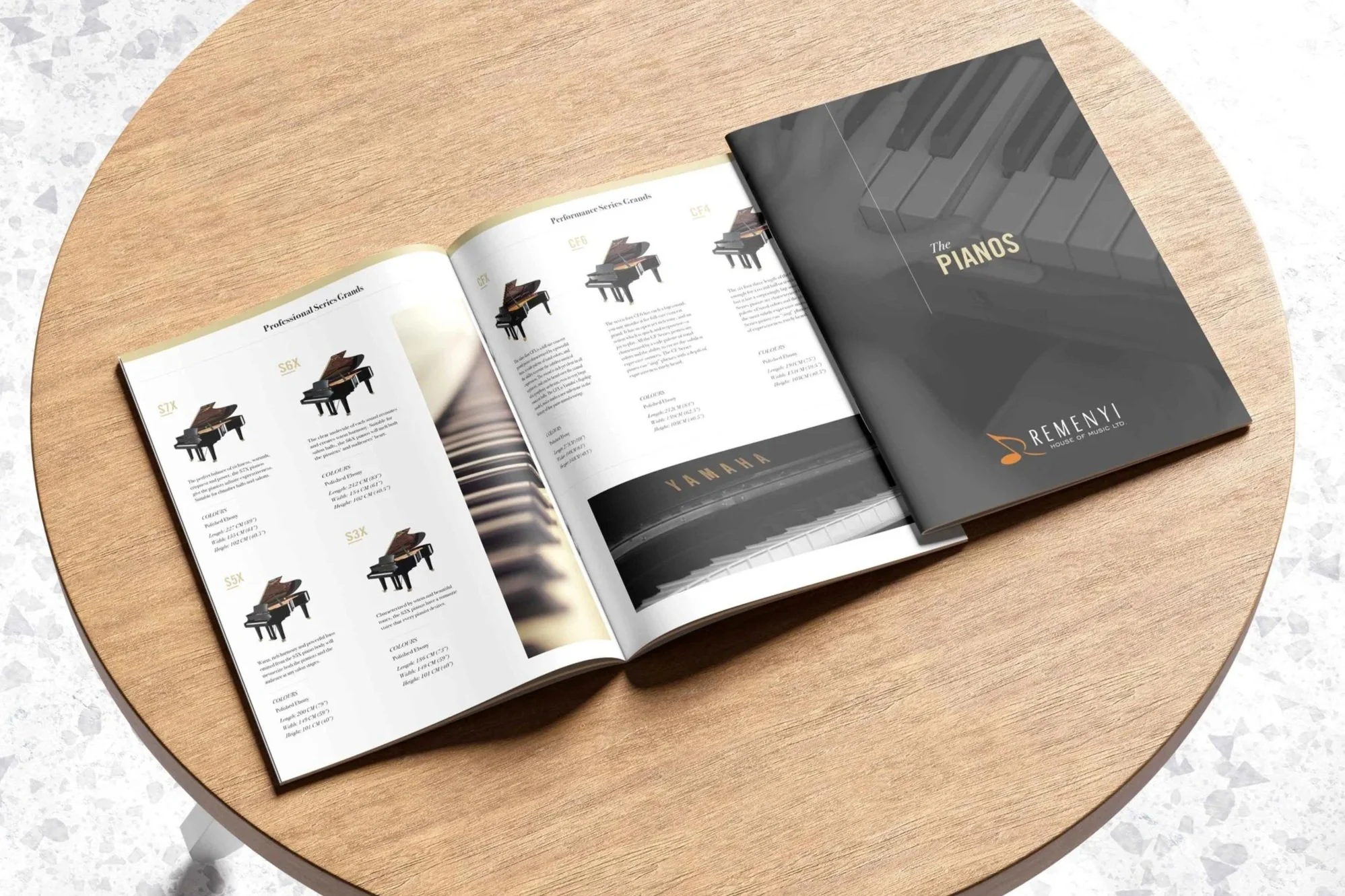 Cover and interior of the Remenyi Piano Catalog laid out on a wooden table.