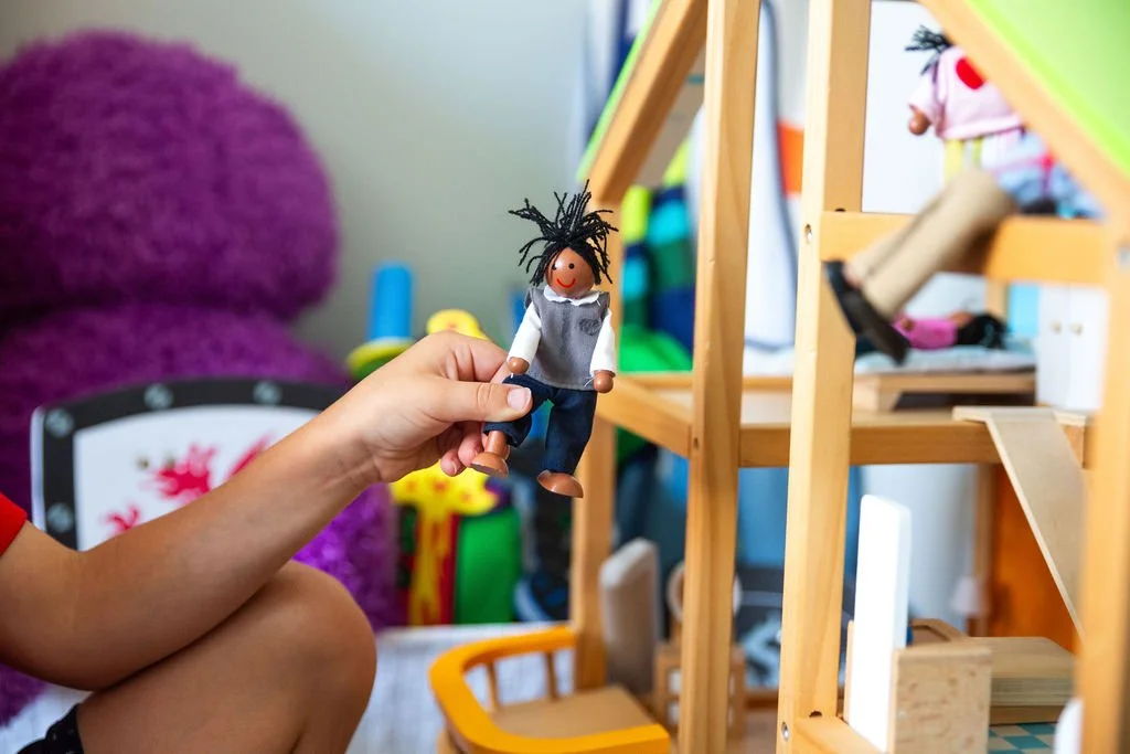 child playing with a dollhouse during a play therapy session in Eden Prairie, MN