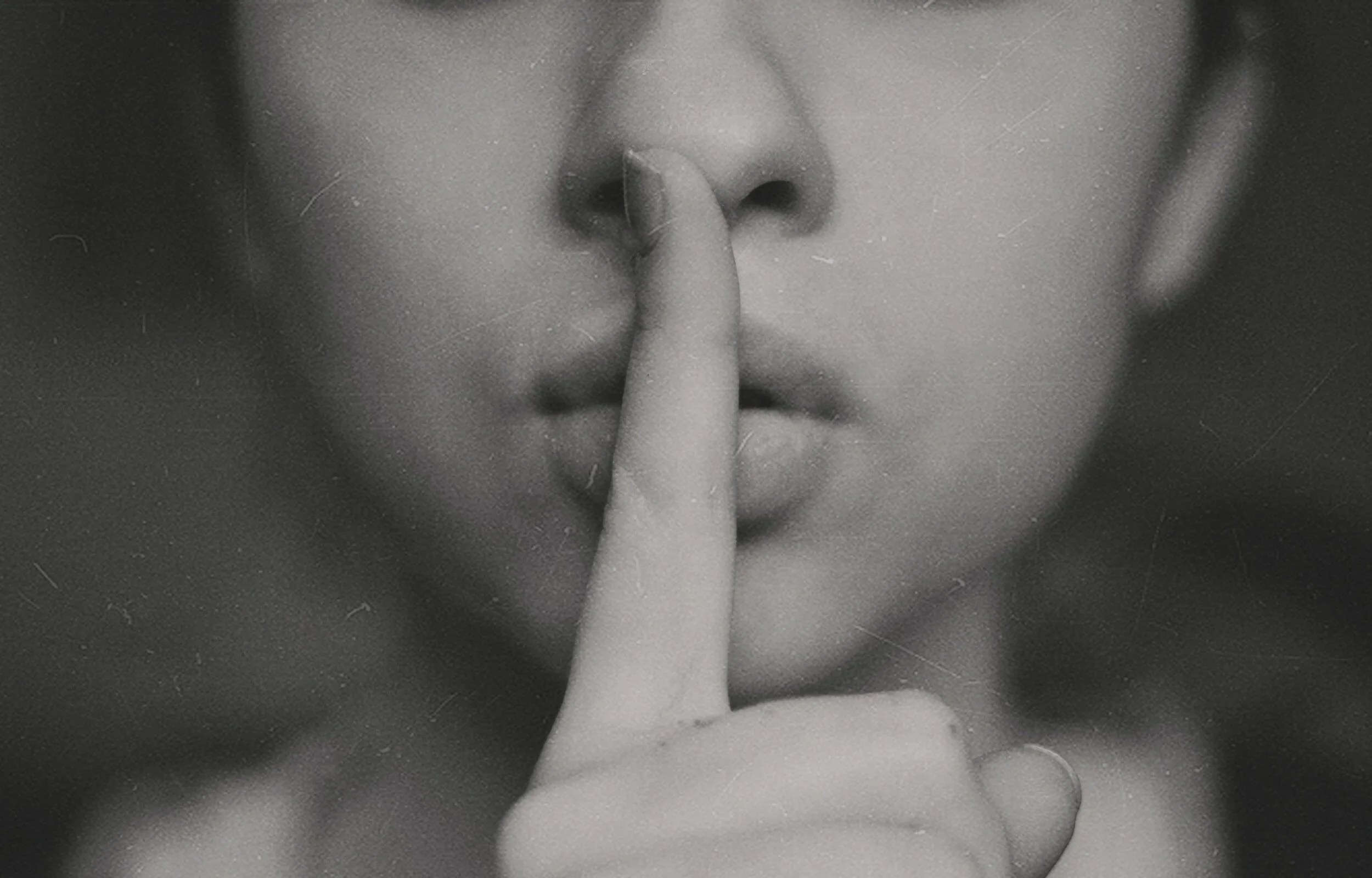 Picture of woman with finger to mouth representing silent treatment of narcissists in divorce.