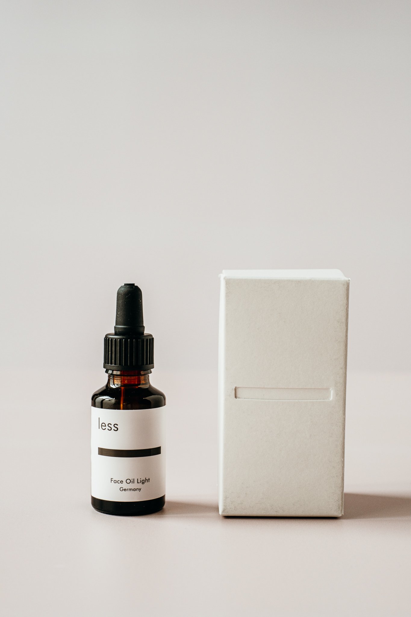 minimalistisches und modernes Produktfoto eines kosmetischen Gesichtsöls und seines Verpackungsmaterials