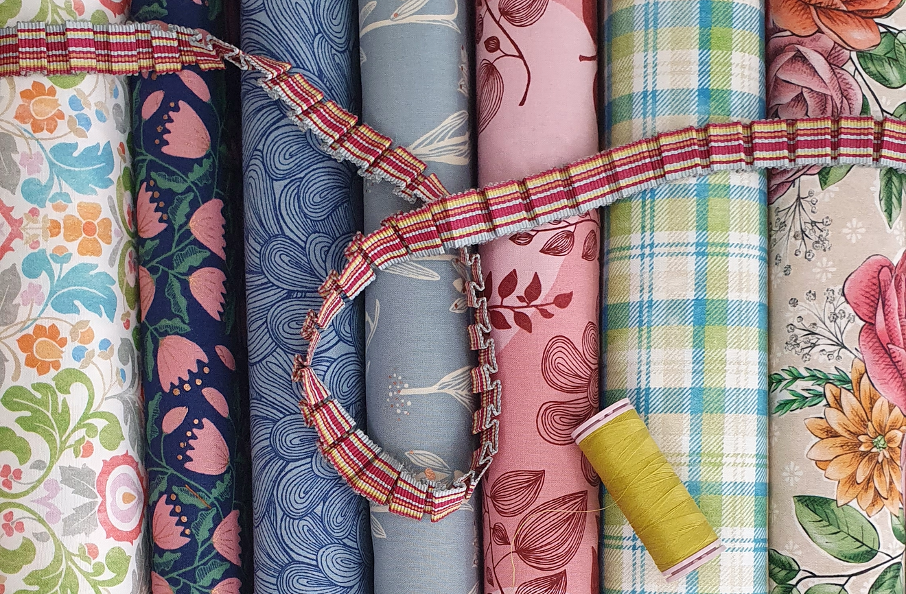 fabric bolts with ribbon and thread.png