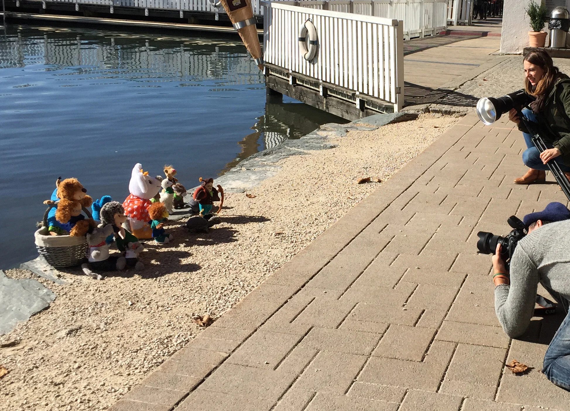 Fotografen fotografieren eine Gruppe von Stofftieren am Ufer des Wörthersees