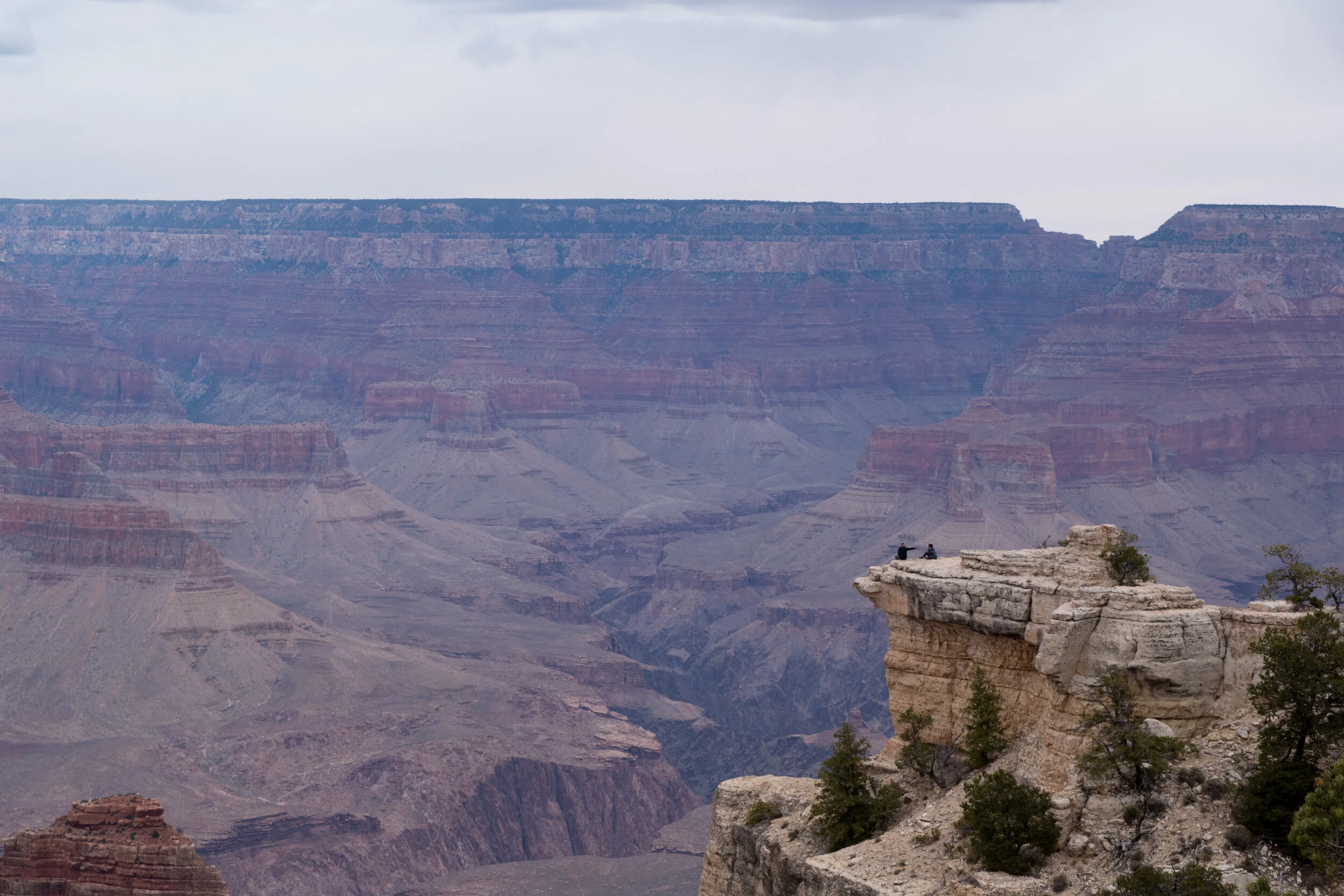 Two people take in the landscape at the Grand Canyon.
