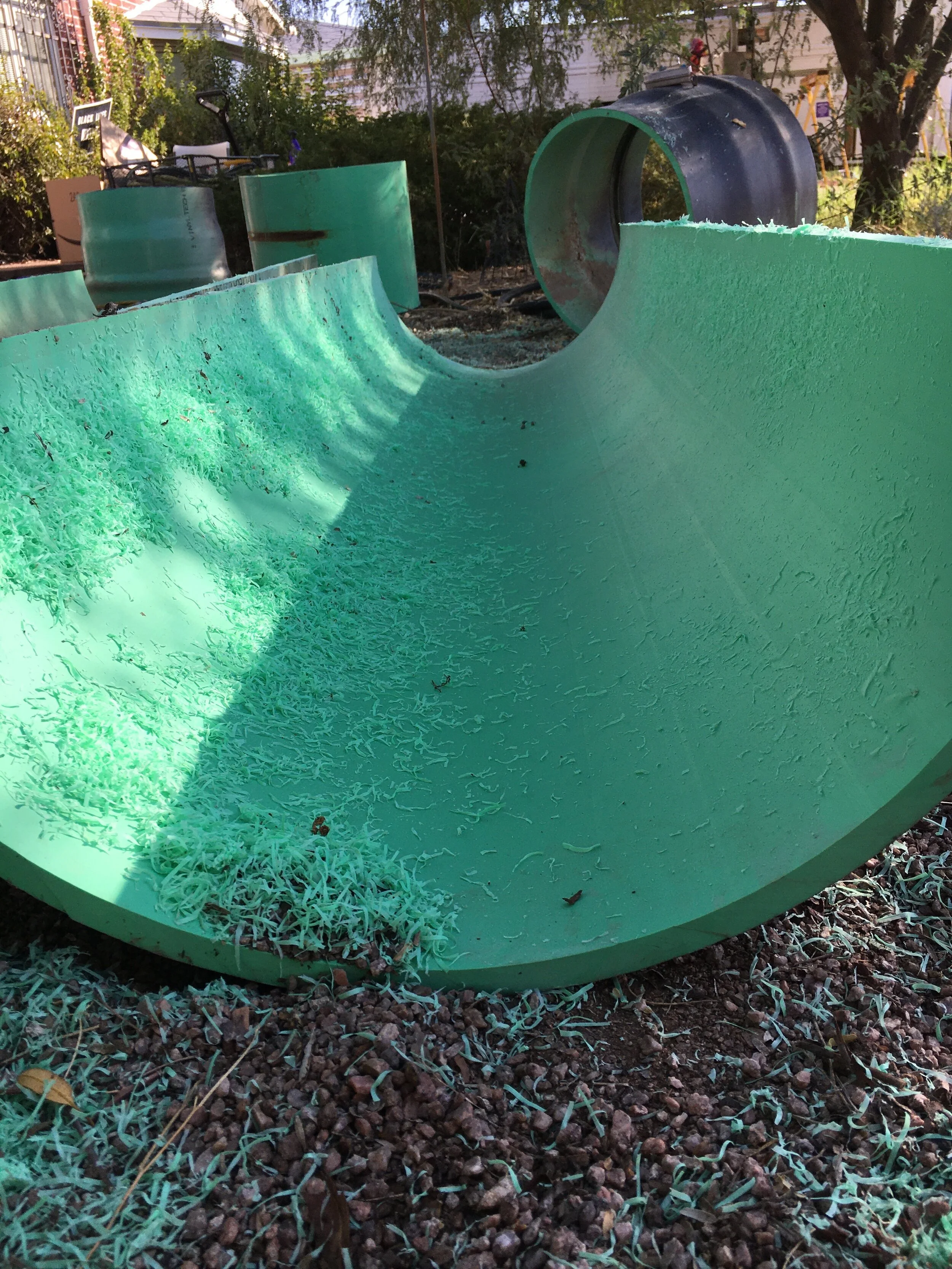 Green PVC water main pipe cut in half to serve as a trough.